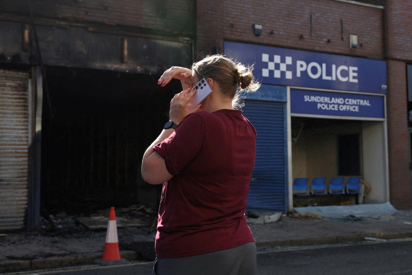 A woman uses a mobile phone next to Sunderland Central Police Office after a night of violent anti-immigrant demonstrations, in Sunderland, Britain, August 3, 2024. REUTERS/Hollie Adams     TPX IMAGES OF THE DAY Photo: Hollie Adams/REUTERS