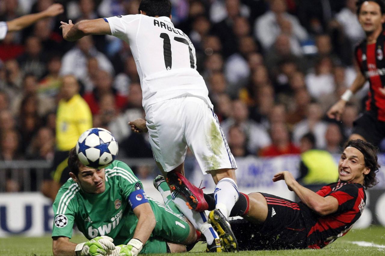 \'AC Milan\'s Zlatan Ibrahimovic (R) battles for the ball with Real Madrid\'s goalkeeper Iker Casillas (L) and Alvaro Arbeloa during their Champions League Group G soccer match at Santiago Bernabeu st