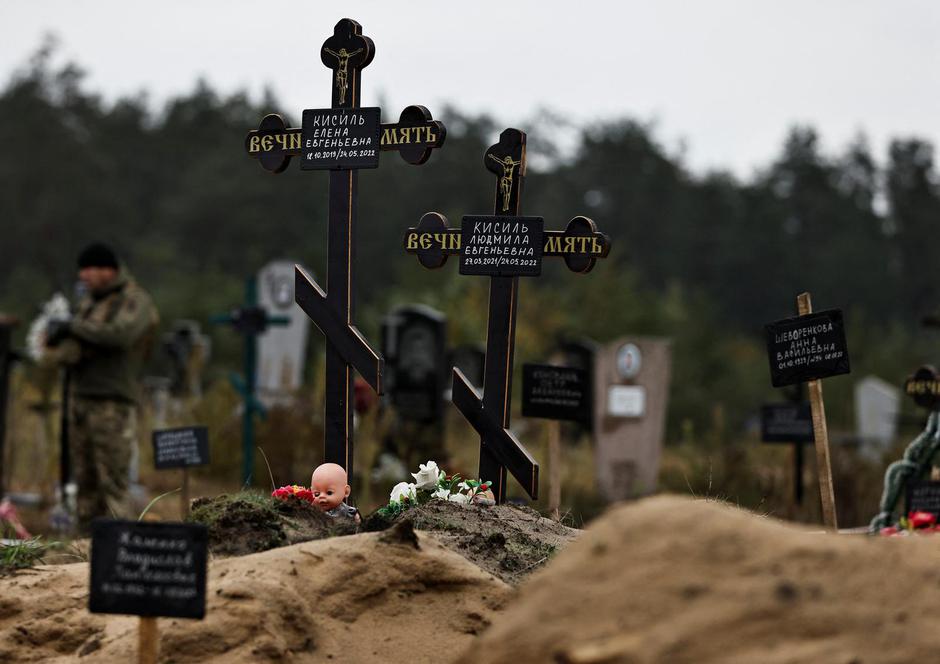 A doll is seen among graves  which Ukrainian officials say is a civilian  mass grave, in the newly recaptured town of Lyman