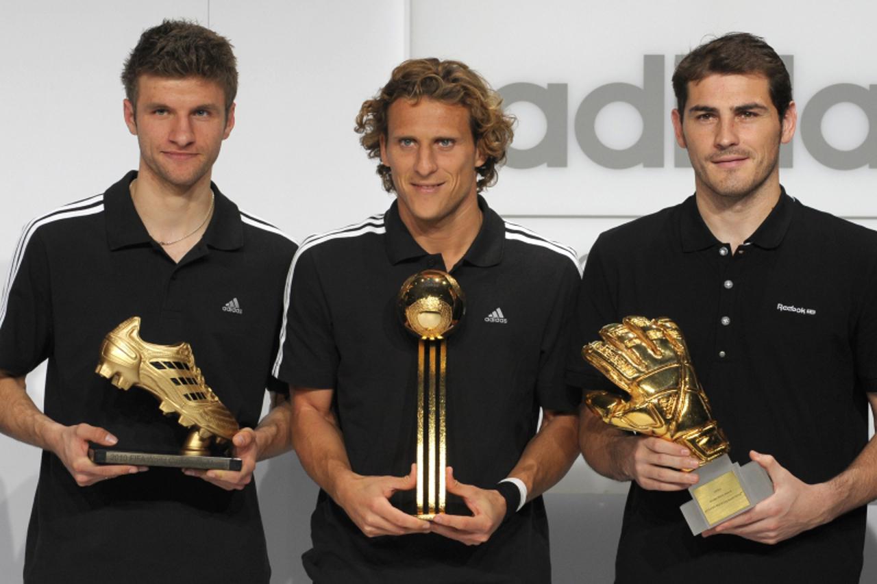 '(L-R) Golden Ball winner Germany\'s striker Thomas Mueller, Golden Boot winner Urugay\'s striker Diego Forlan and Golden Glove winner Spain\'s goalkeeper Iker Casillas pose with their awards during t