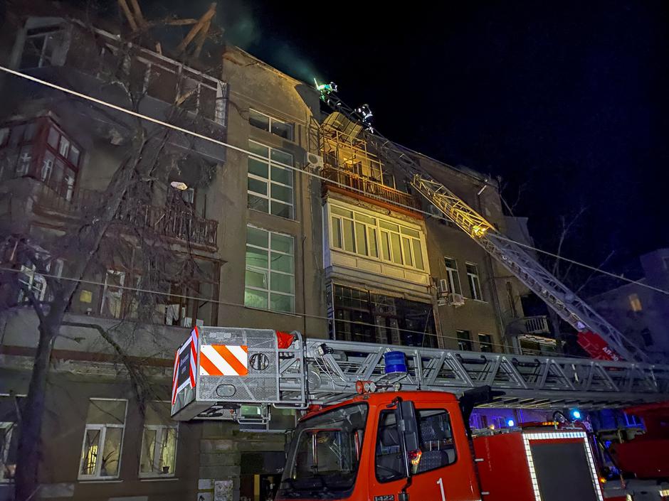 Ukrainian firefighters work at a site of an apartment building severely damaged by a Russian missile in Kharkiv