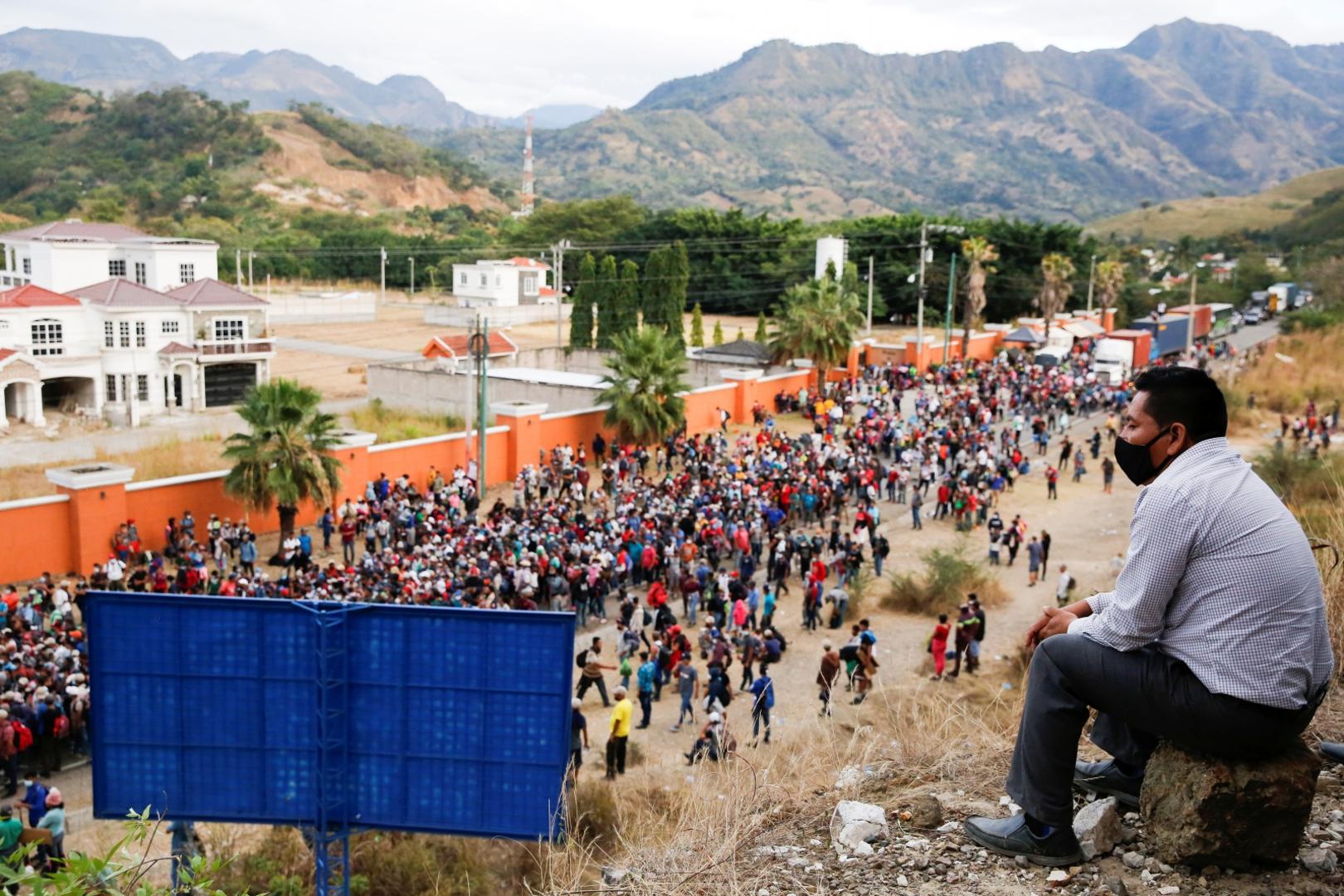 Hondurans take part in a new caravan of migrants, set to head to the United States, in Vado Hondo Hondurans taking part in a new caravan of migrants, set to head to the United States, gather on a road blocked by police officers (not pictured), in Vado Hondo, Guatemala January 17, 2021. REUTERS/Luis Echeverria LUIS ECHEVERRIA