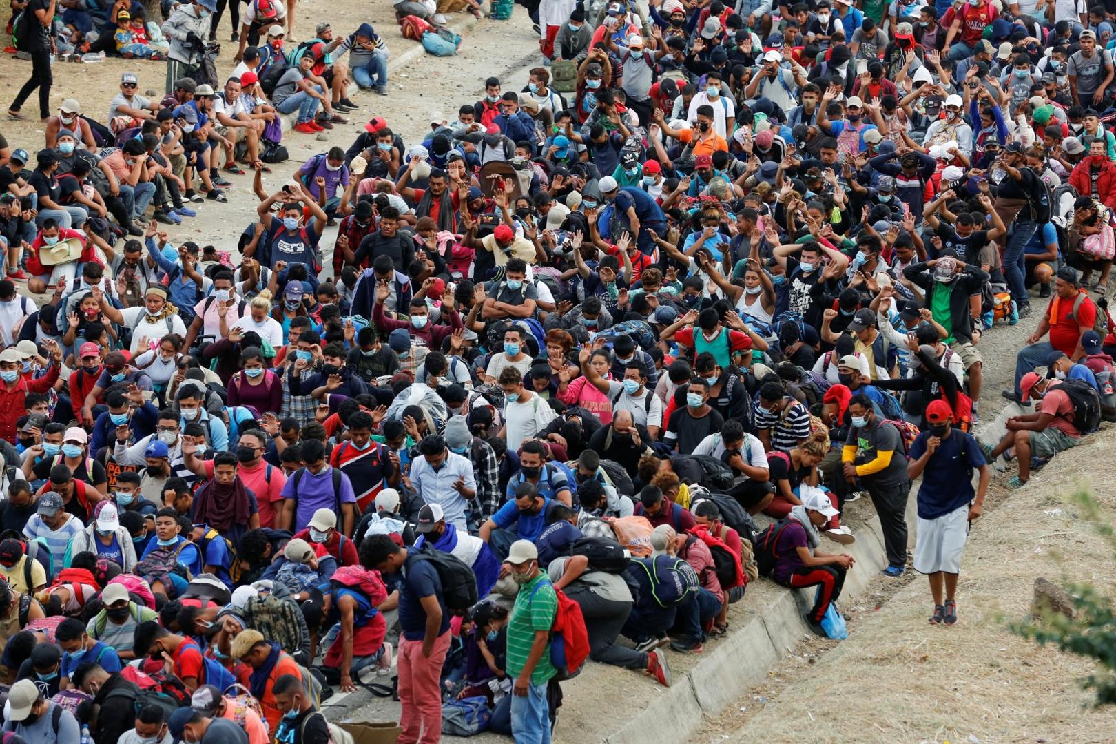 Hondurans take part in a new caravan of migrants, set to head to the United States, in Vado Hondo Hondurans taking part in a new caravan of migrants, set to head to the United States, gather on a road blocked by police officers (not pictured), in Vado Hondo, Guatemala January 17, 2021. REUTERS/Luis Echeverria LUIS ECHEVERRIA