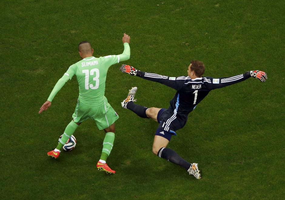 Germany's goalkeeper Manuel Neuer challenges Algeria's Islam Slimani during their 2014 World Cup round of 16 game at the Beira Rio stadium in Porto Alegre June 30, 2014. REUTERS/Fabrizio Bensch (BRAZIL  - Tags: SOCCER SPORT WORLD CUP)