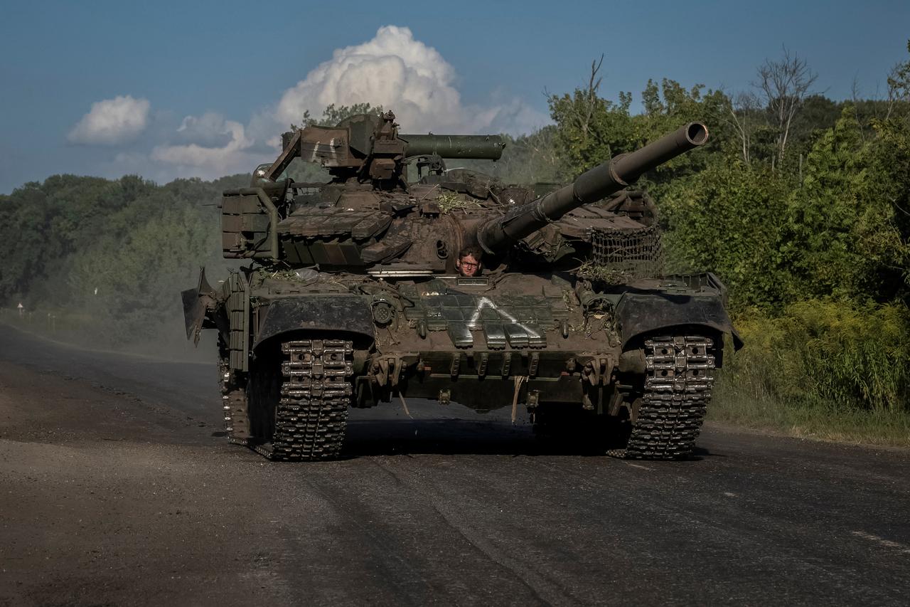 Ukrainian servicemen ride a tank near the Russian border in Sumy region