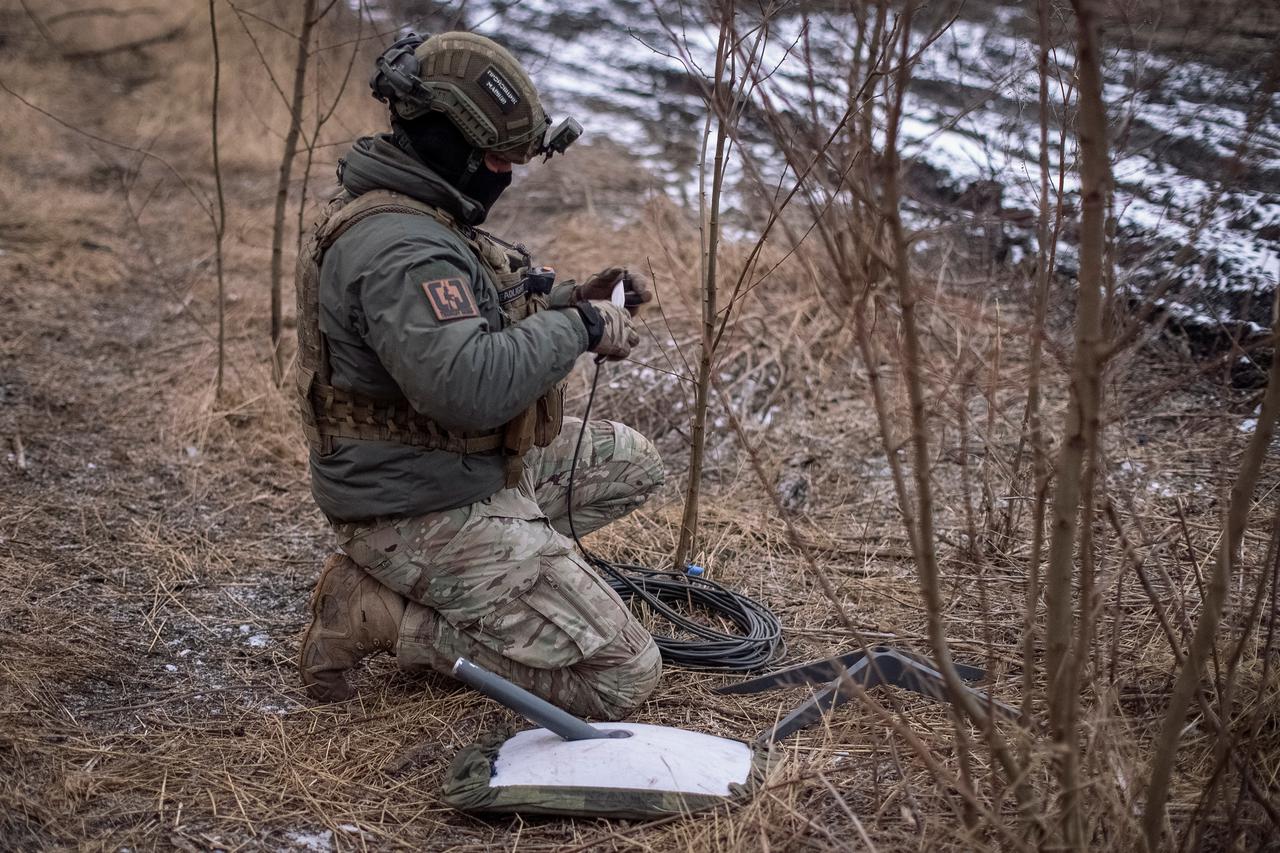 A Ukrainian serviceman of 47th brigade prepares a Starlink satellite internet systems at his positions at a front line the town of Avdiivka