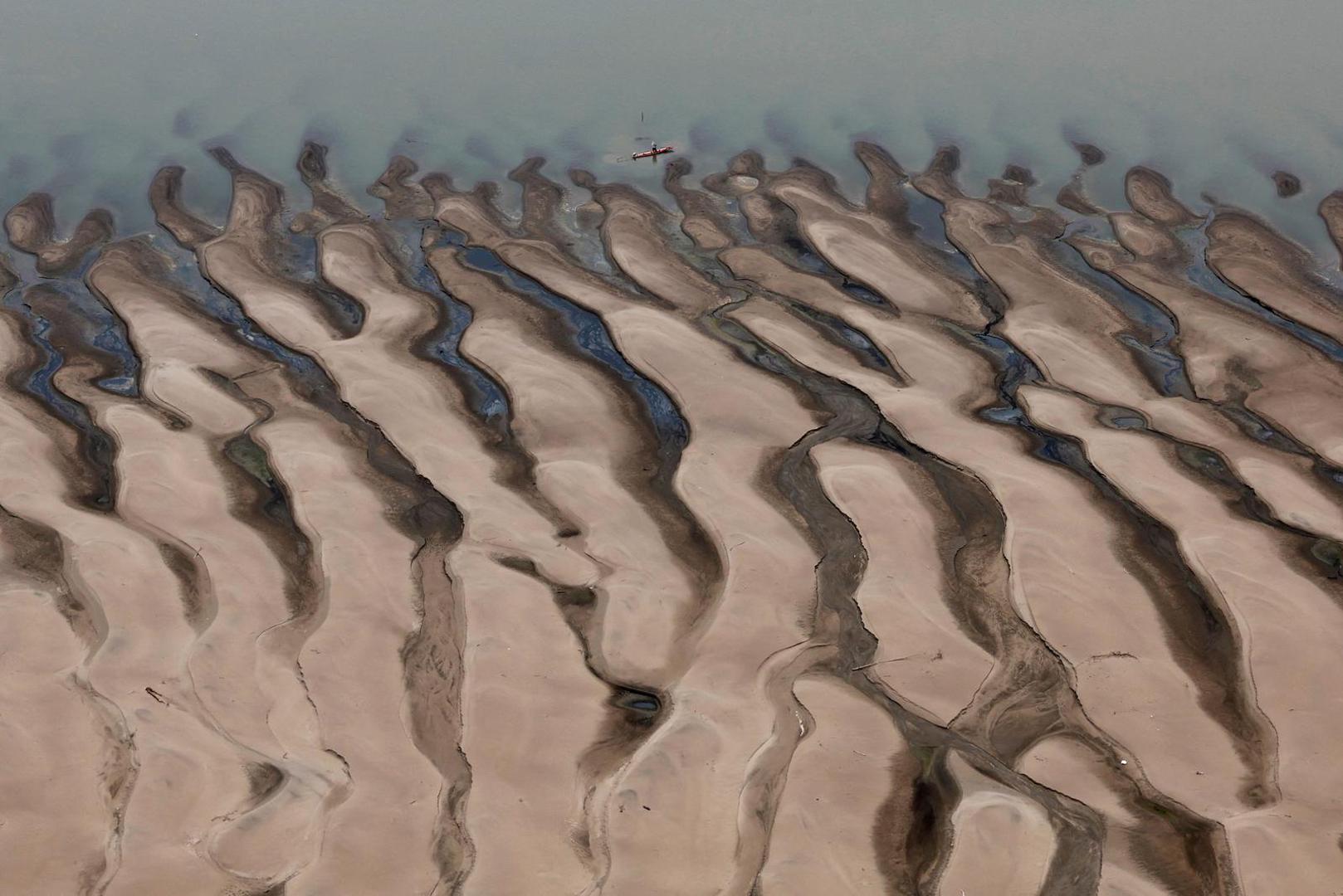 A man rides a boat in front of the sandbanks at the Solimoes River, one of the largest tributaries of the Amazon River, during a Greenpeace flyover to inspect what the National Center for Monitoring and Early Warning of Natural Disasters (Cemaden) says is the most intense and widespread drought Brazil has experienced since records began in 1950, near Tefe, Amazonas state, Brazil September 17, 2024. REUTERS/Jorge Silva     TPX IMAGES OF THE DAY Photo: JORGE SILVA/REUTERS