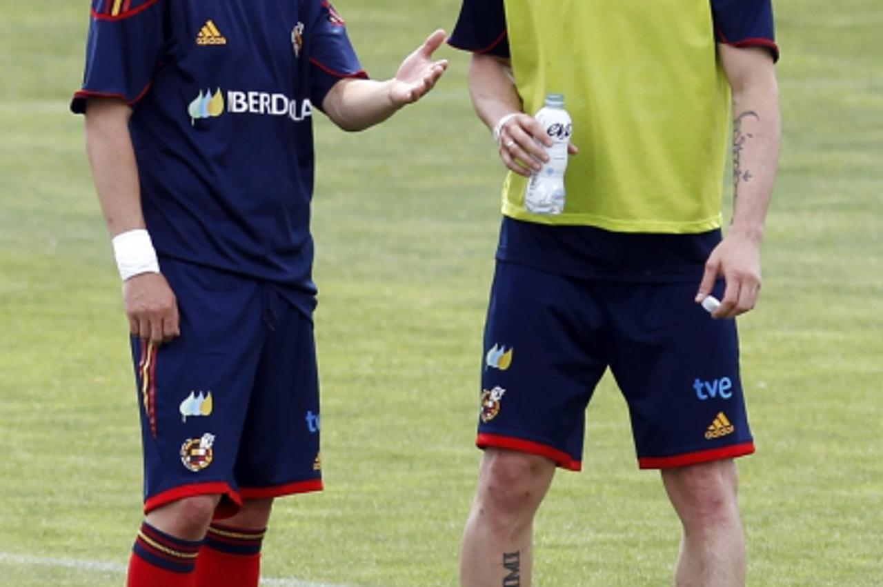 'Spain\'s national soccer team players David Villa (L) and Fernando Torres talk during a training session at the Spanish Soccer Federation headquarters in Las Rozas, outside Madrid, May 27, 2010. REUT