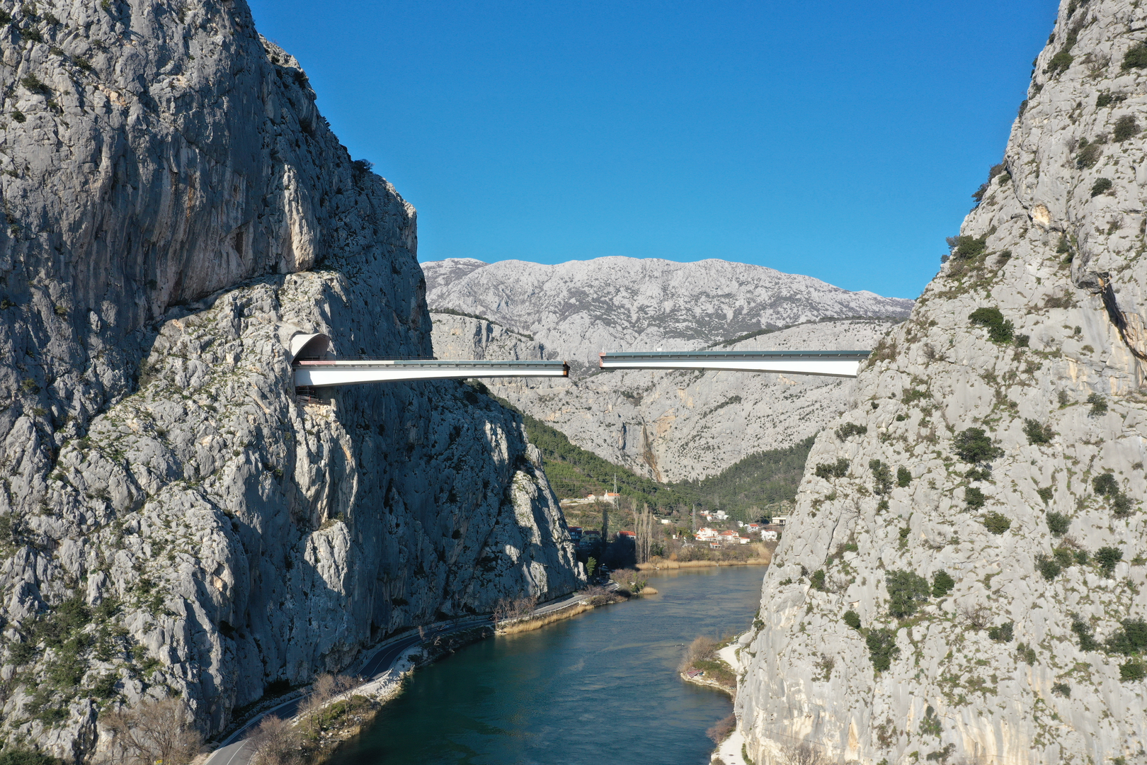 09.02.2023., Omis - Spajanje mosta iznad rijeke Cetine kod Omisa na 70 metara nadmorske visine koji je dio omiske zaobilaznice. Omiska obilaznica jedan od najvecih infrastrukturnih objekata u Splitsko-dalmatinskoj zupaniji, a zaobilaznicu ukljucuju dva tunela i most preko Cetine, tunel Komorjak dug vise od 600 metara, a Omis vise od 500 metara, dok ce most biti u duzini od 216 metara. Investitor je tvrtka Hrvatske ceste, koja je za prvu fazu brze ceste Split - Omis izdvojila 174,5 milijuna kuna, a s radovima se pocelo u rujnu 2019.  Photo: Matko Begovic/PIXSELL