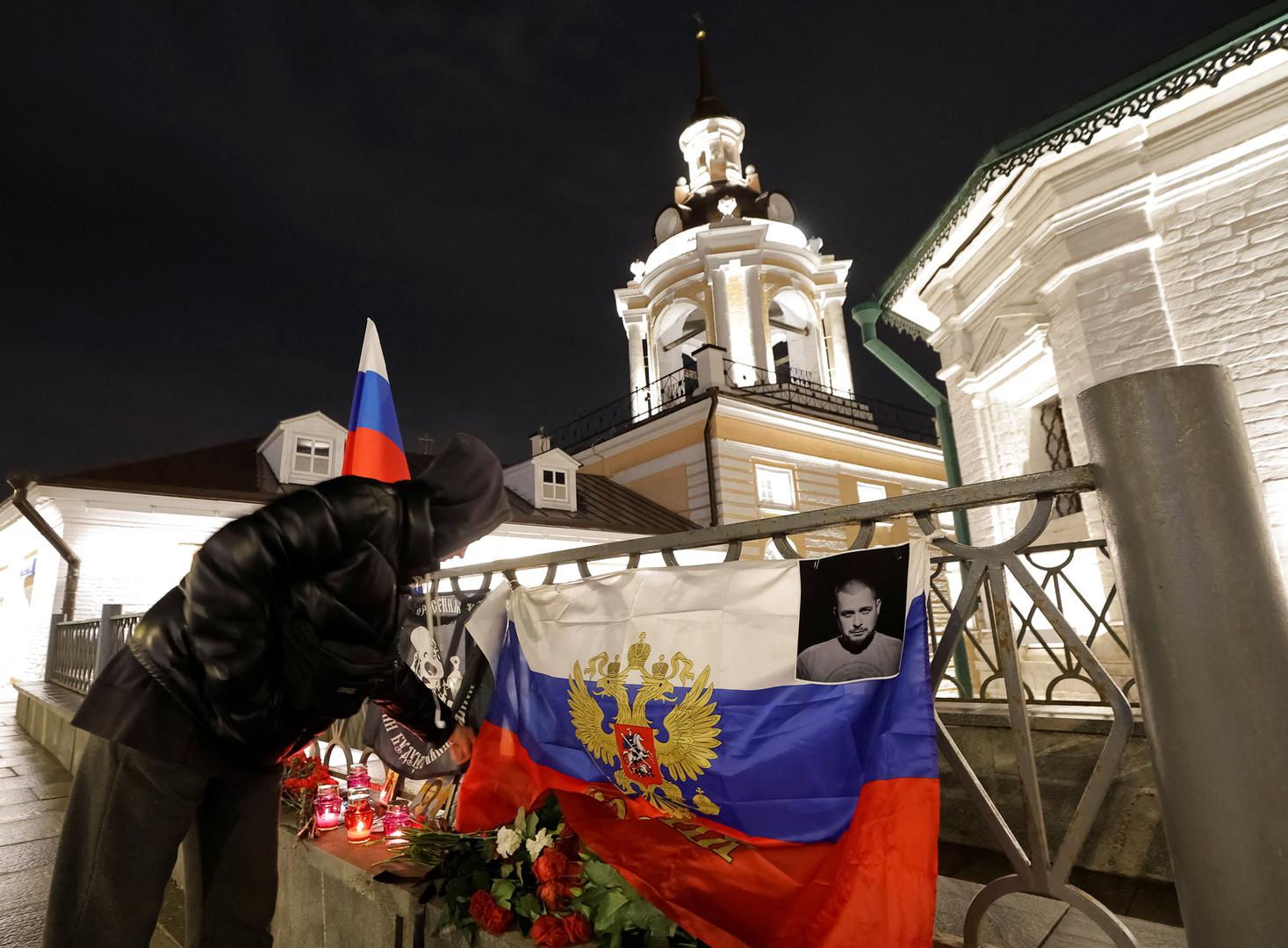 A woman arranges flowers and flags at the improvised memorial for Russian military blogger Vladlen Tatarsky, (real name Maxim Fomin), who was killed in a cafe explosion a day before, in Moscow, Russia April 3, 2023. REUTERS/Maxim Shemetov Photo: MAXIM SHEMETOV/REUTERS