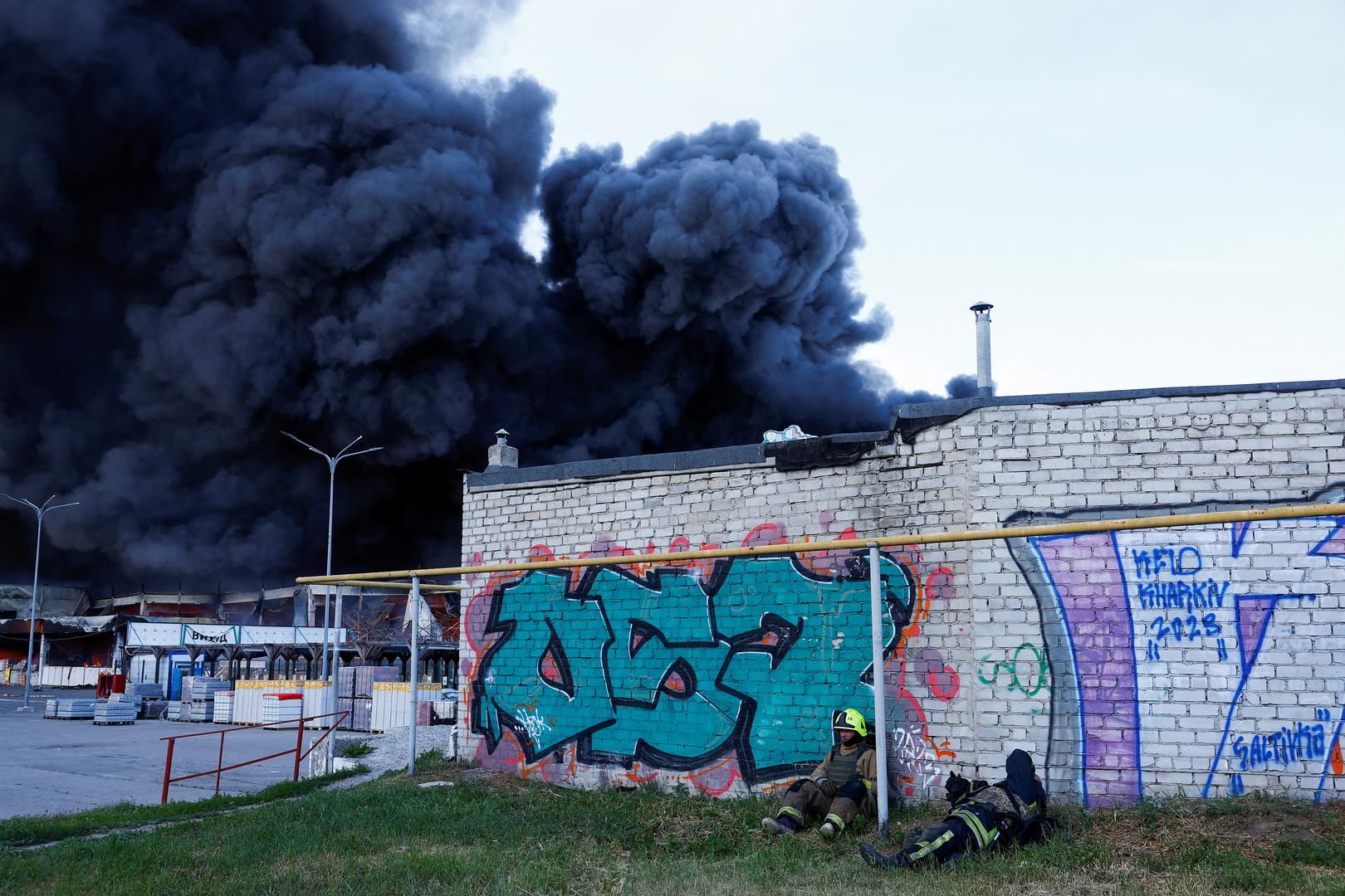 Firefighters rest, as smoke rises from a household item shopping mall which was hit by a Russian air strike, amid Russia's attack on Ukraine, in Kharkiv, Ukraine May 25, 2024. REUTERS/Valentyn Ogirenko Photo: VALENTYN OGIRENKO/REUTERS