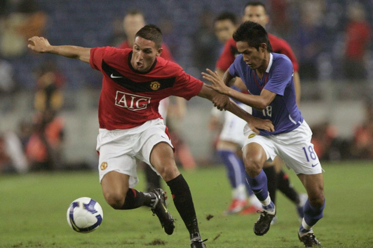 \'Manchesster United\'s Federico Macheda (L) controls the ball away from Malaysia XI\'s Mazlizam Mohd during their friendly match at Bukit Jalil National stadium in Kuala Lumpur July 20, 2009. REUTERS