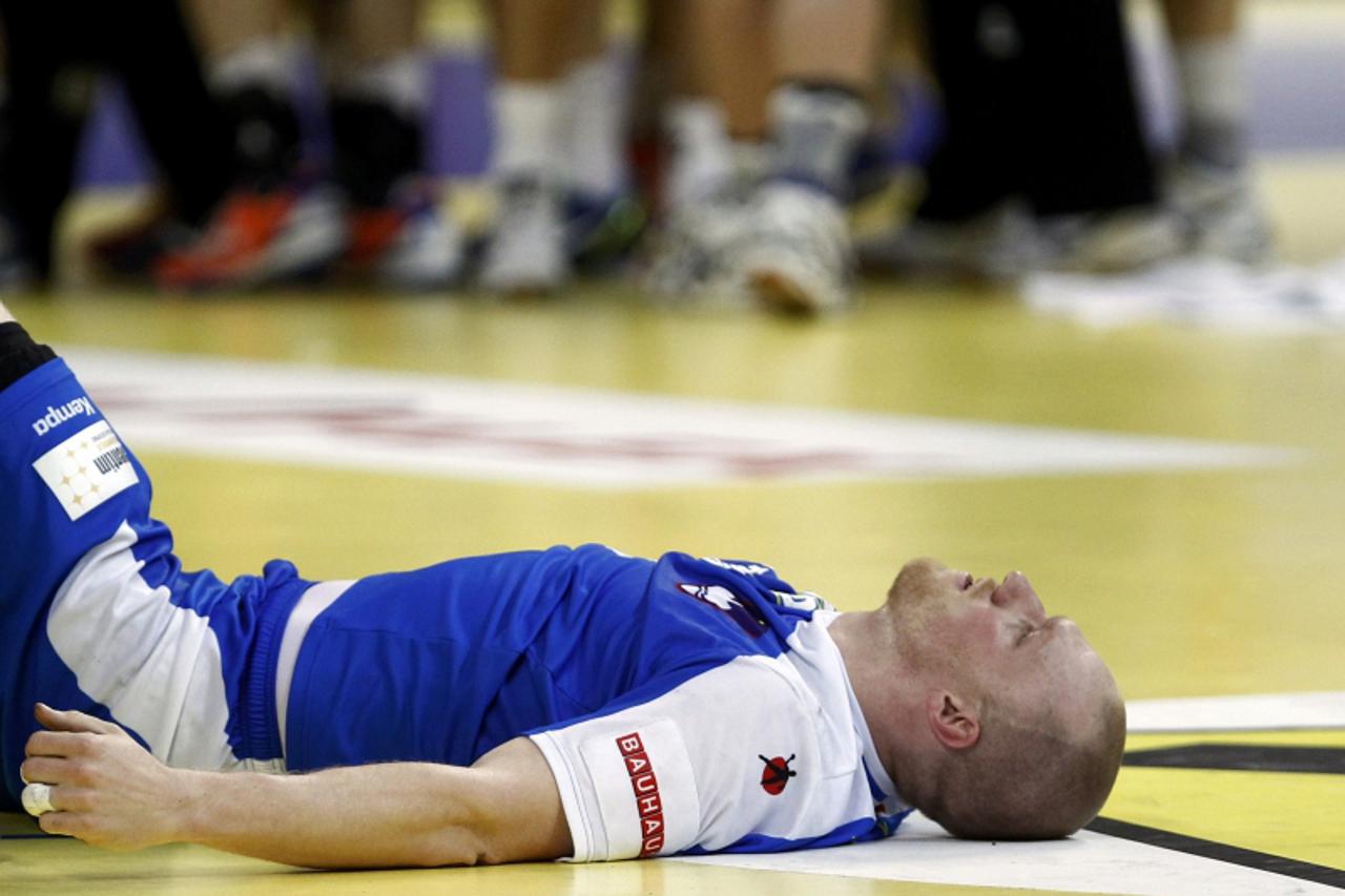 'Slovenia\'s Miha Zvizej reacts after his team was defeated by Macedonia during their men\'s European Handball Championship match for the fifth place in Belgrade January 27, 2012. REUTERS/Ivan Milutin