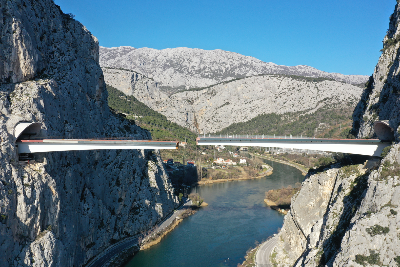 09.02.2023., Omis - Spajanje mosta iznad rijeke Cetine kod Omisa na 70 metara nadmorske visine koji je dio omiske zaobilaznice. Omiska obilaznica jedan od najvecih infrastrukturnih objekata u Splitsko-dalmatinskoj zupaniji, a zaobilaznicu ukljucuju dva tunela i most preko Cetine, tunel Komorjak dug vise od 600 metara, a Omis vise od 500 metara, dok ce most biti u duzini od 216 metara. Investitor je tvrtka Hrvatske ceste, koja je za prvu fazu brze ceste Split - Omis izdvojila 174,5 milijuna kuna, a s radovima se pocelo u rujnu 2019.  Photo: Matko Begovic/PIXSELL