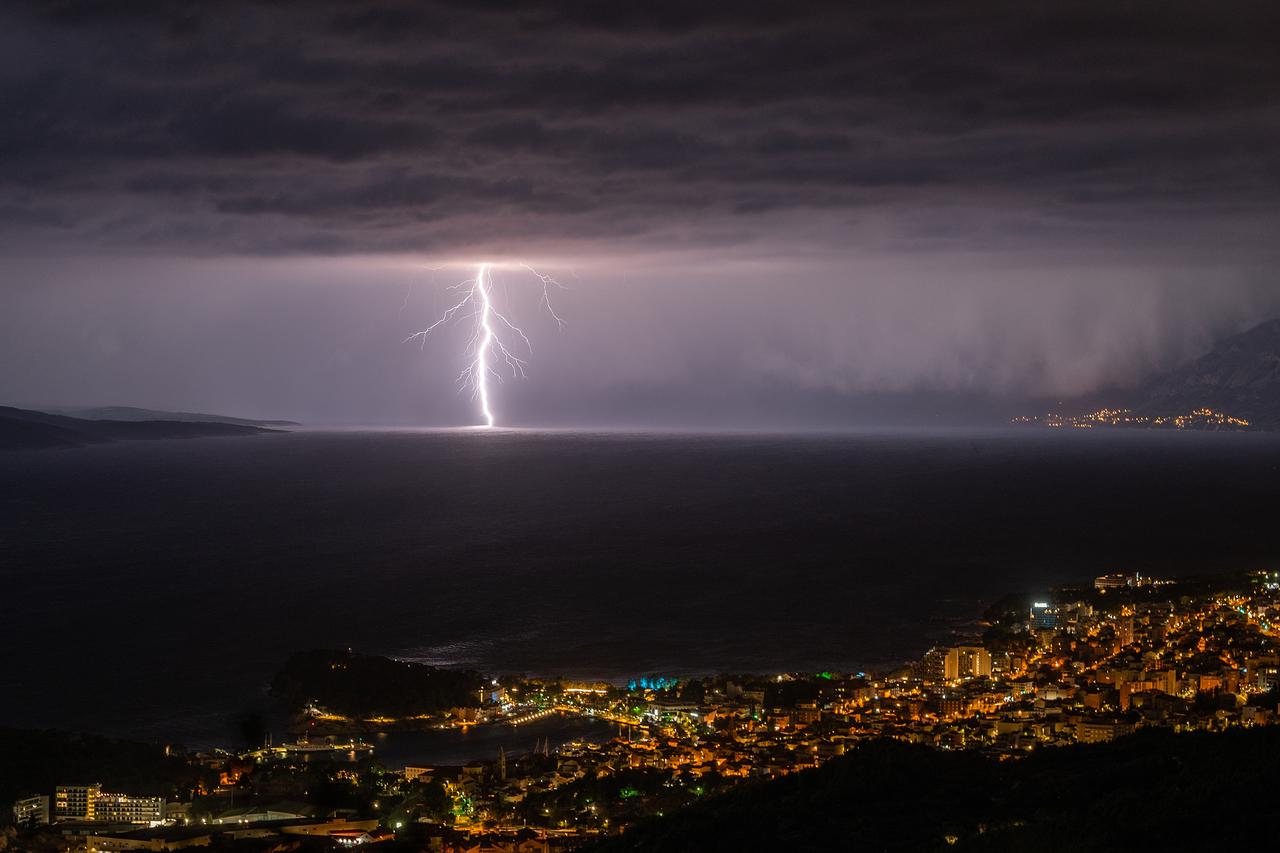 Pogled na Makarsku i munje u bračkom kanalu prema Splitu