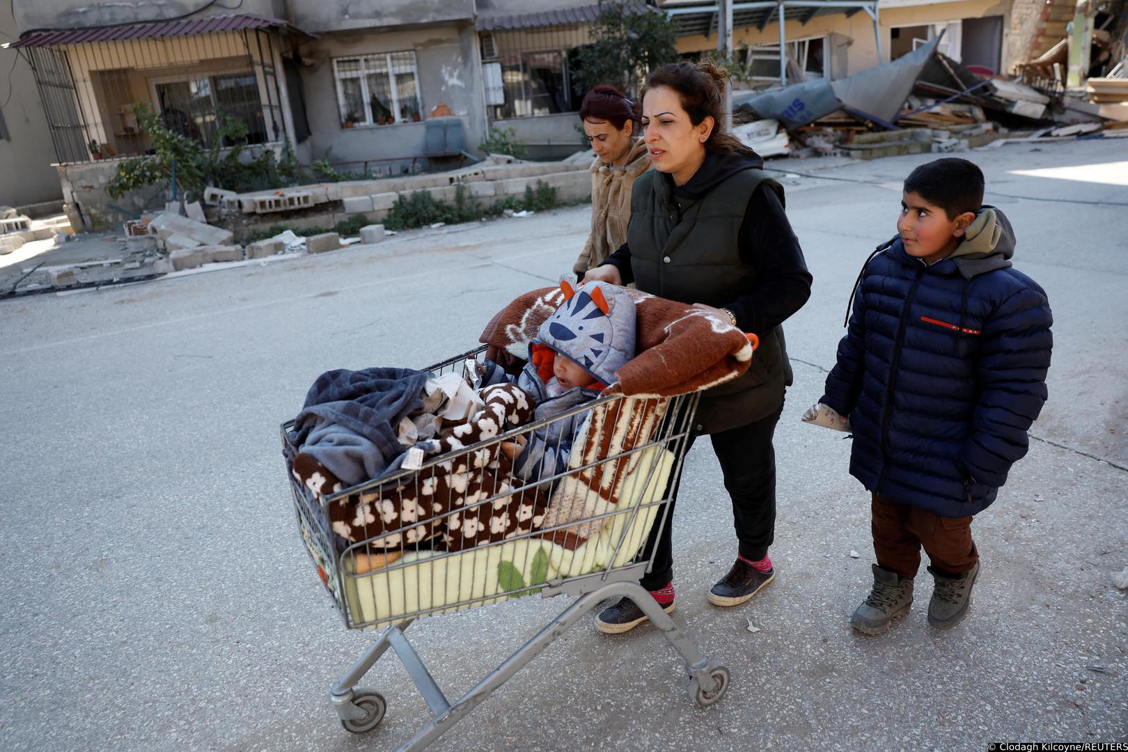 Parlakgun family return to their tent with mother Tulay pushing baby Salih in a shopping trolly through the destroyed streets in the aftermath of a deadly earthquake in Hatay, Turkey February 14, 2023. REUTERS/Clodagh Kilcoyne Photo: Clodagh Kilcoyne/REUTERS