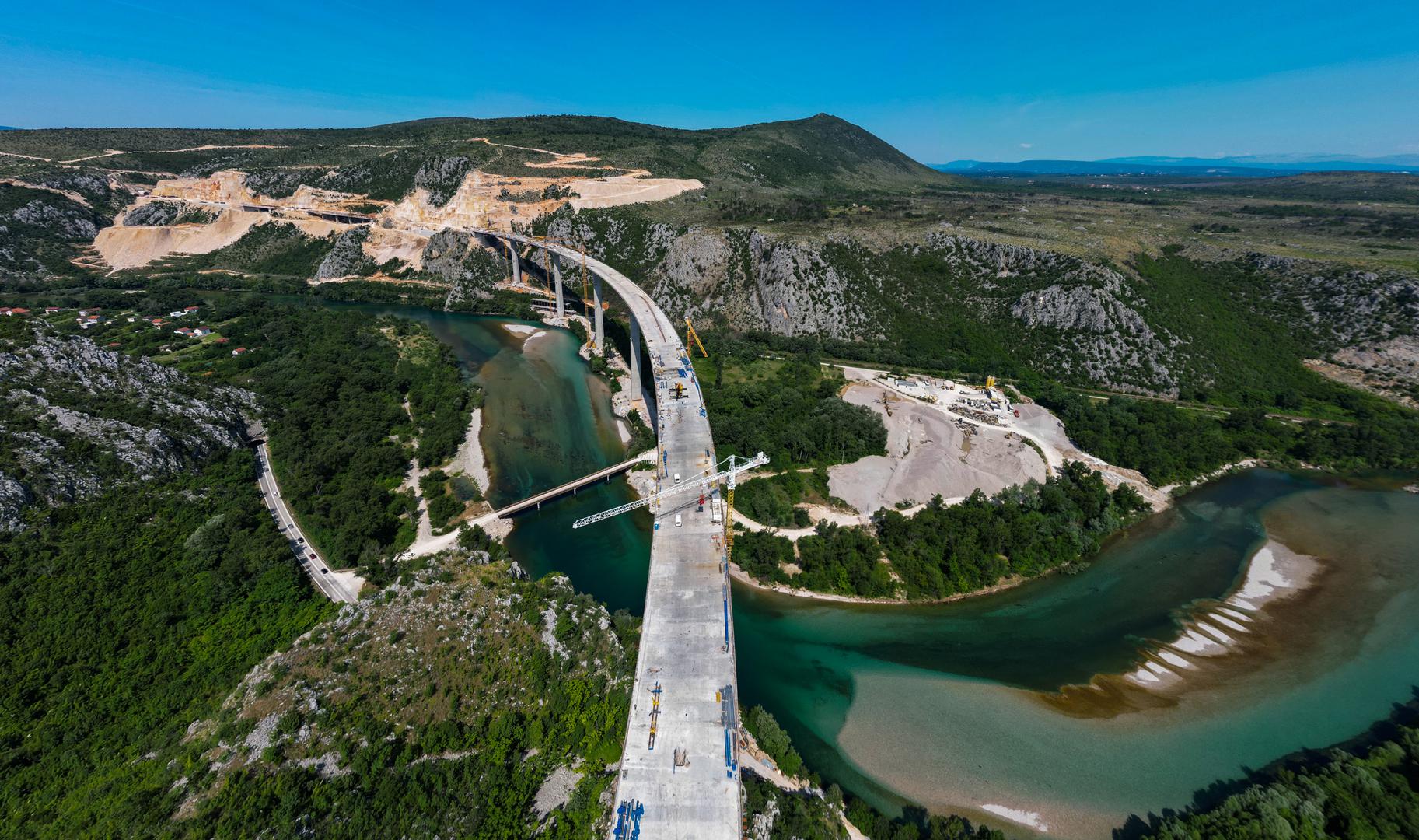 18.06.2023.,Capljina -  Jedan od najvisih mostova u regiji, most Pocitelj uskoro ce biti  spojen s lijevom obalom Neretve. Most Pocitelj visok je nesto vise od stotinu metara, dok njegova duzina iznosi 918 metara. Most ce imati dva vozna traka u svakom smjeru, te je projektiran za brzinu do 130 kilometara na sat. Specificnost ovog mosta je da se citava sirina raspona nalazi na jednostrukom nizu stupova, tj, kolnici nisu fizicki odvojeni. Most Pocitelj najveci je objekt na koridoru Vc. 


 Photo: Denis Kapetanovic/PIXSELL