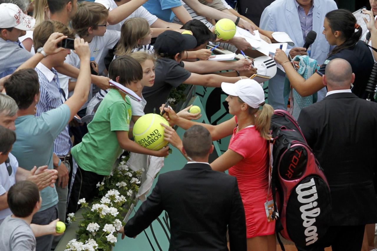 'Petra Martic of Croatia (C) signs autographes as she leaves after winning her match against Marion Bartoli of France during the French Open tennis tournament at the Roland Garros stadium in Paris May