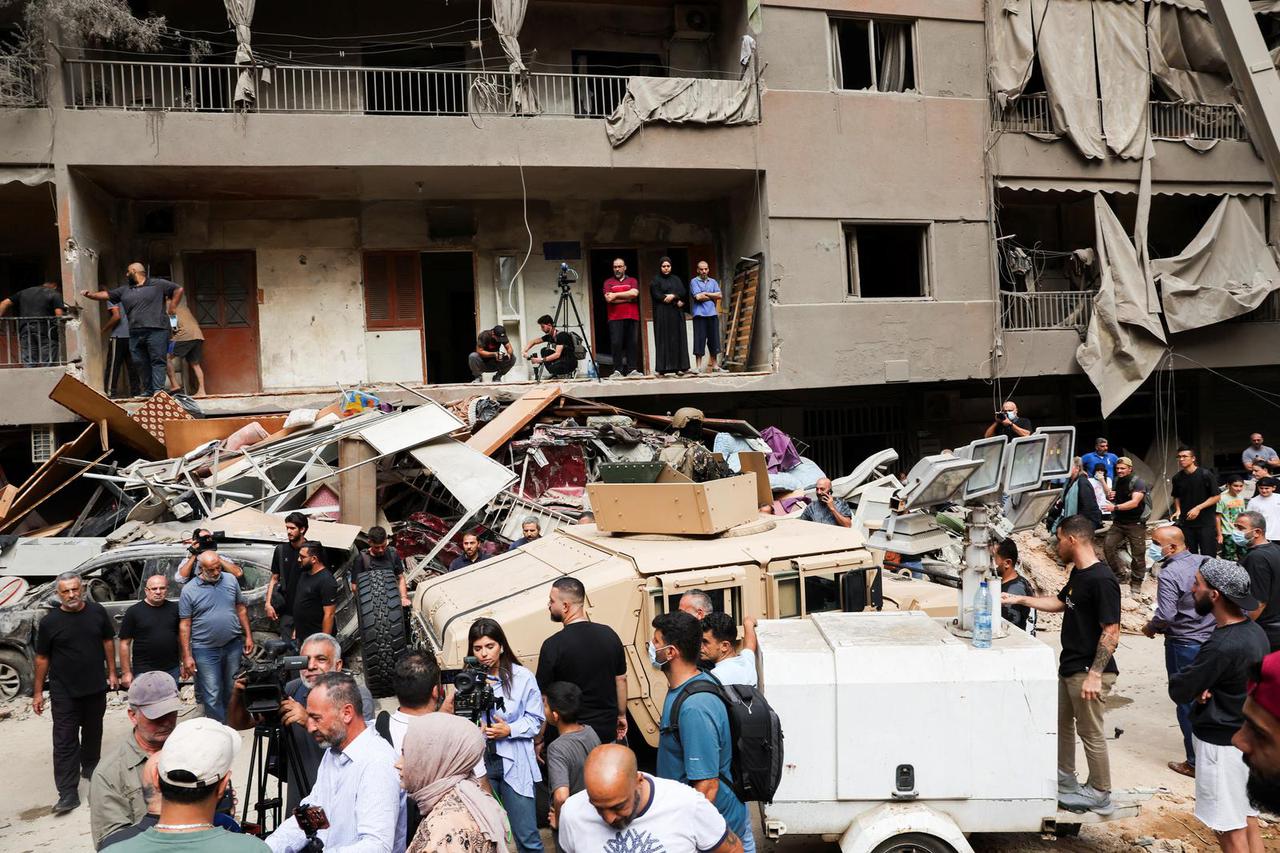 People and media workers gather at the site of an Israeli strike after Iran's parliament speaker Mohammad Baqer Qalibaf's visit, in Beirut