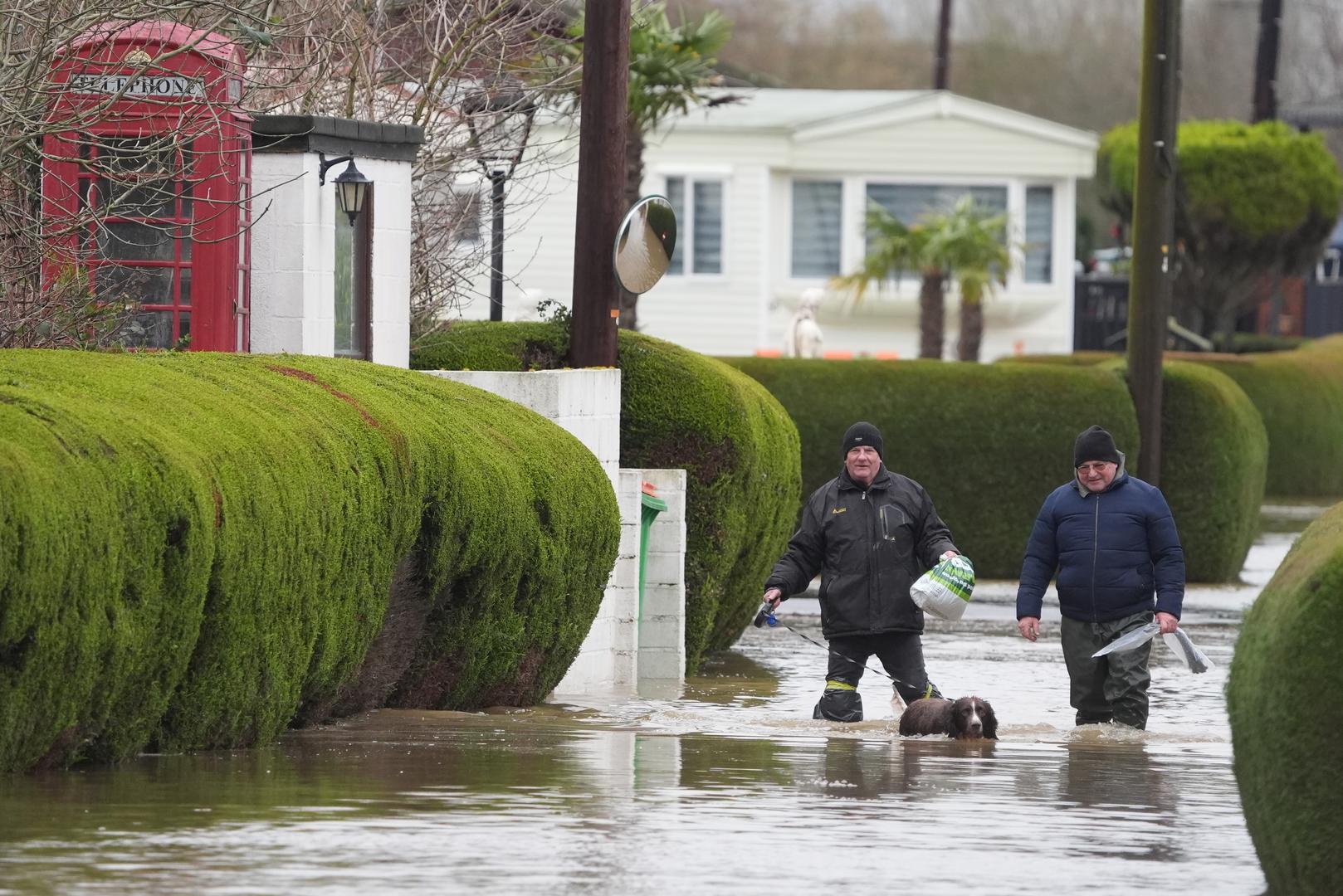 People walk through flood water at the Little Venice caravan park in Yalding Kent. Weather warnings remain in force across much of the UK on Monday with adverse conditions, including flooding from heavy rain and thawing snow. Picture date: Monday January 6, 2025. Photo: Gareth Fuller/PRESS ASSOCIATION