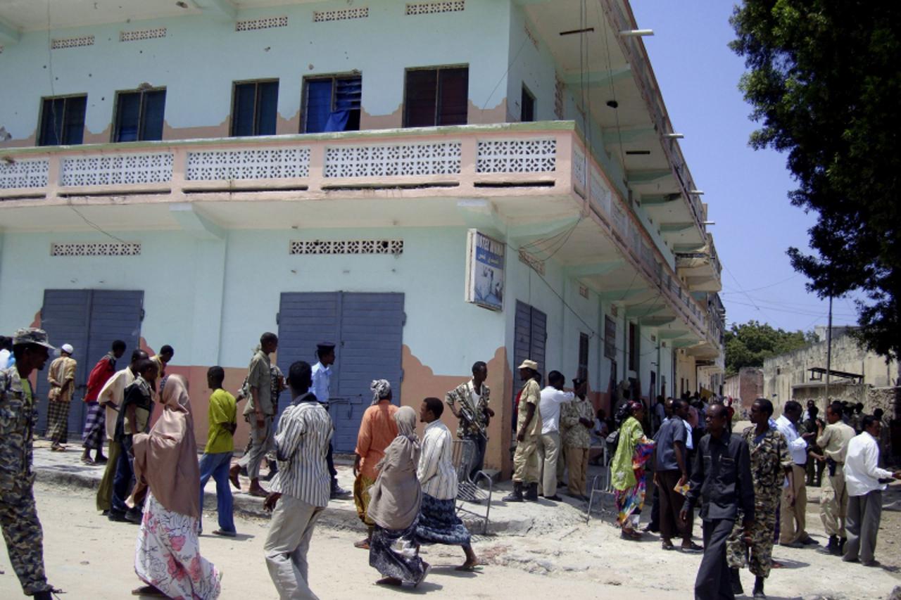 'People gather around Muna Hotel, the site of an armed attack in Mogadishu August 24, 2010. Gunmen in army uniforms stormed a hotel in the Somali capital Mogadishu frequented by government officials o