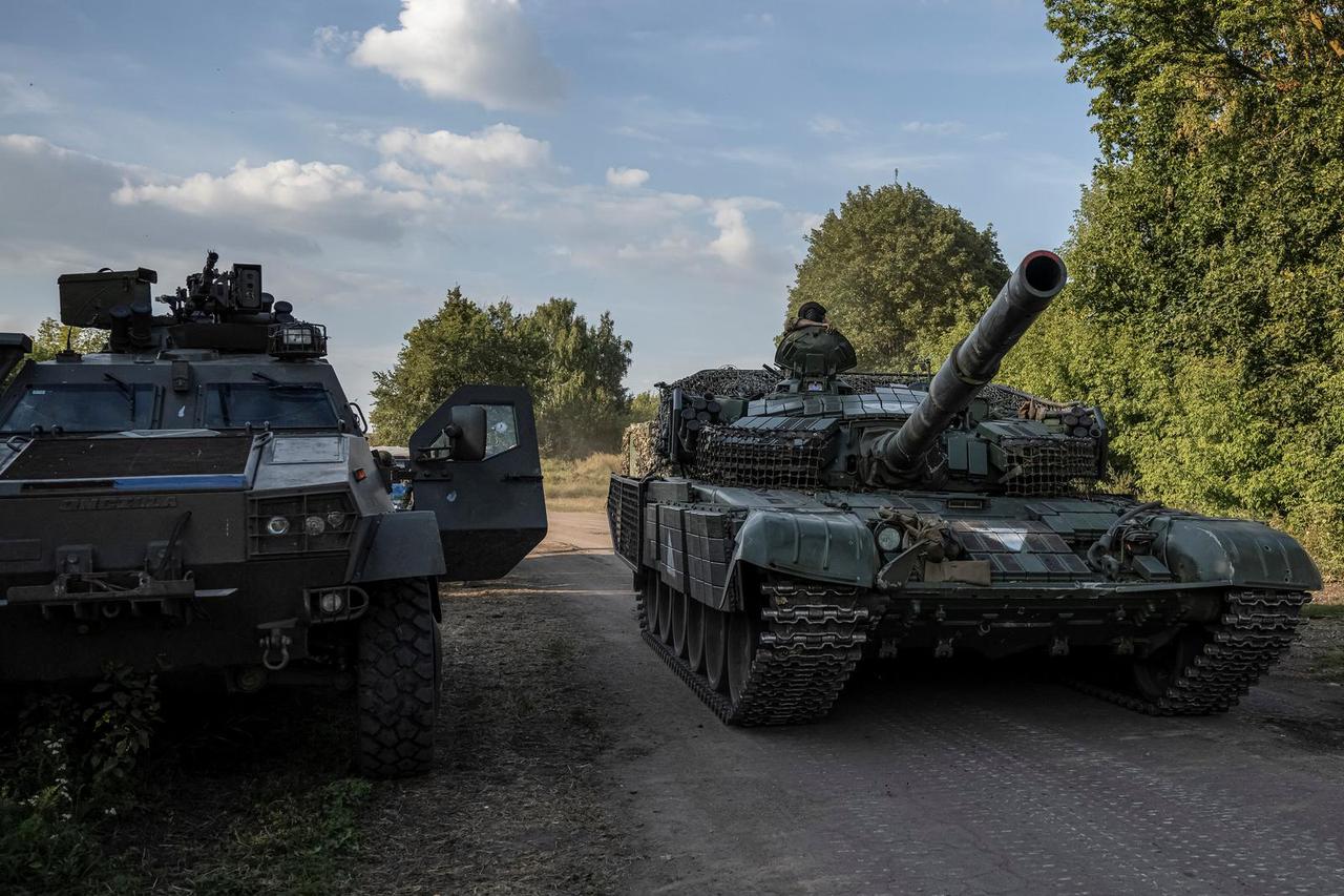 Ukrainian servicemen ride a tank near the Russian border in Sumy region