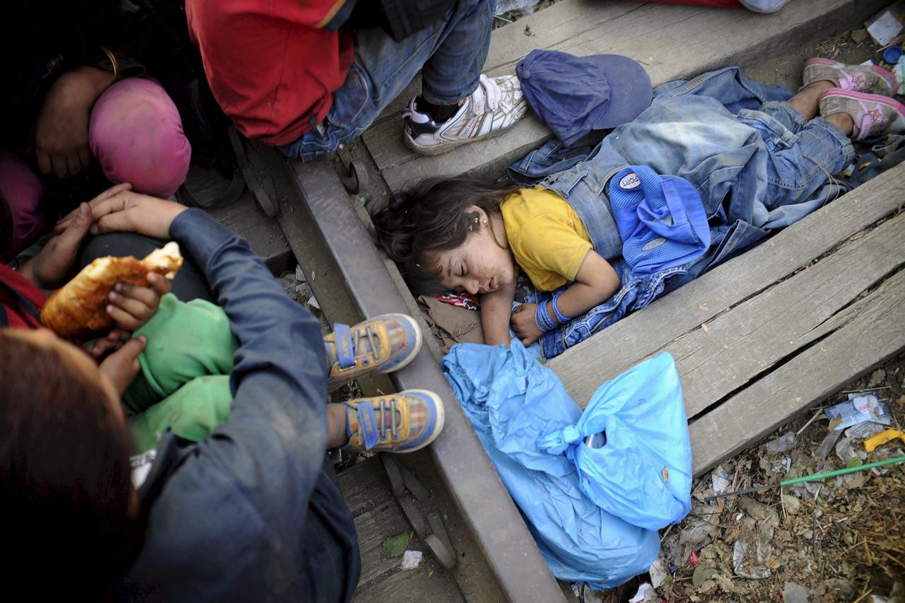 Four-year-old Rashida from Kobani, Syria, part of a new group of more than a thousand immigrants, sleeps as they wait on the border between Macedonia and Greece to enter Macedonia near Gevgelija railway station August 20, 2015.  REUTERS/Ognen Teofilovski 