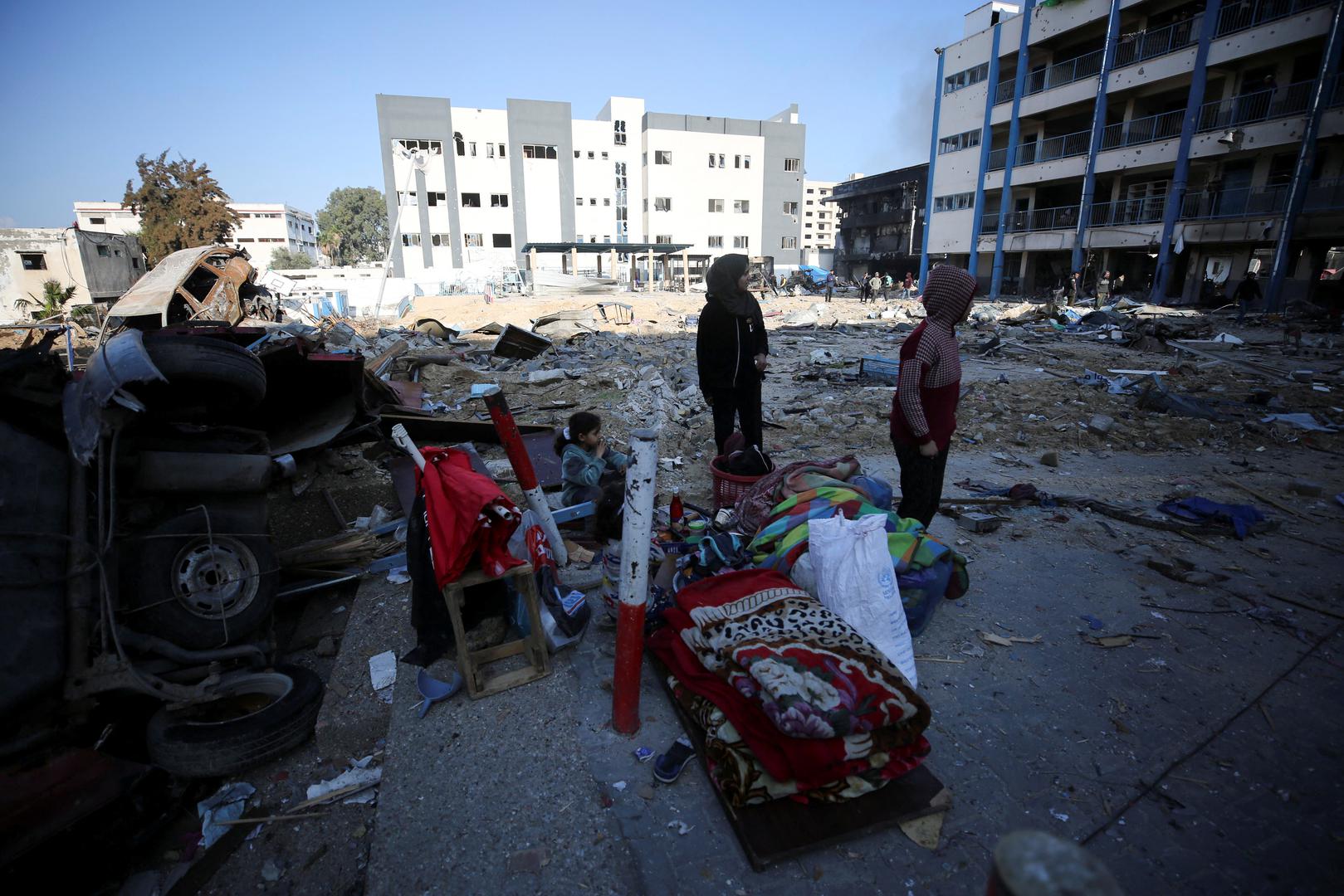 Palestinians stand near the damaged UNRWA school, following an Israeli ground operation, amid the ongoing conflict between Israel and Hamas, in Gaza City, February 10, 2024. REUTERS/Stringer Photo: Stringer/REUTERS