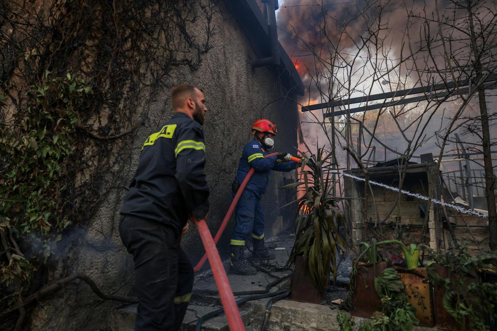 Firefighters try to extinguish a wildfire burning a house in Dionysos, Greece, August 12, 2024. REUTERS/Alexandros Avramidis Photo: ALEXANDROS AVRAMIDIS/REUTERS