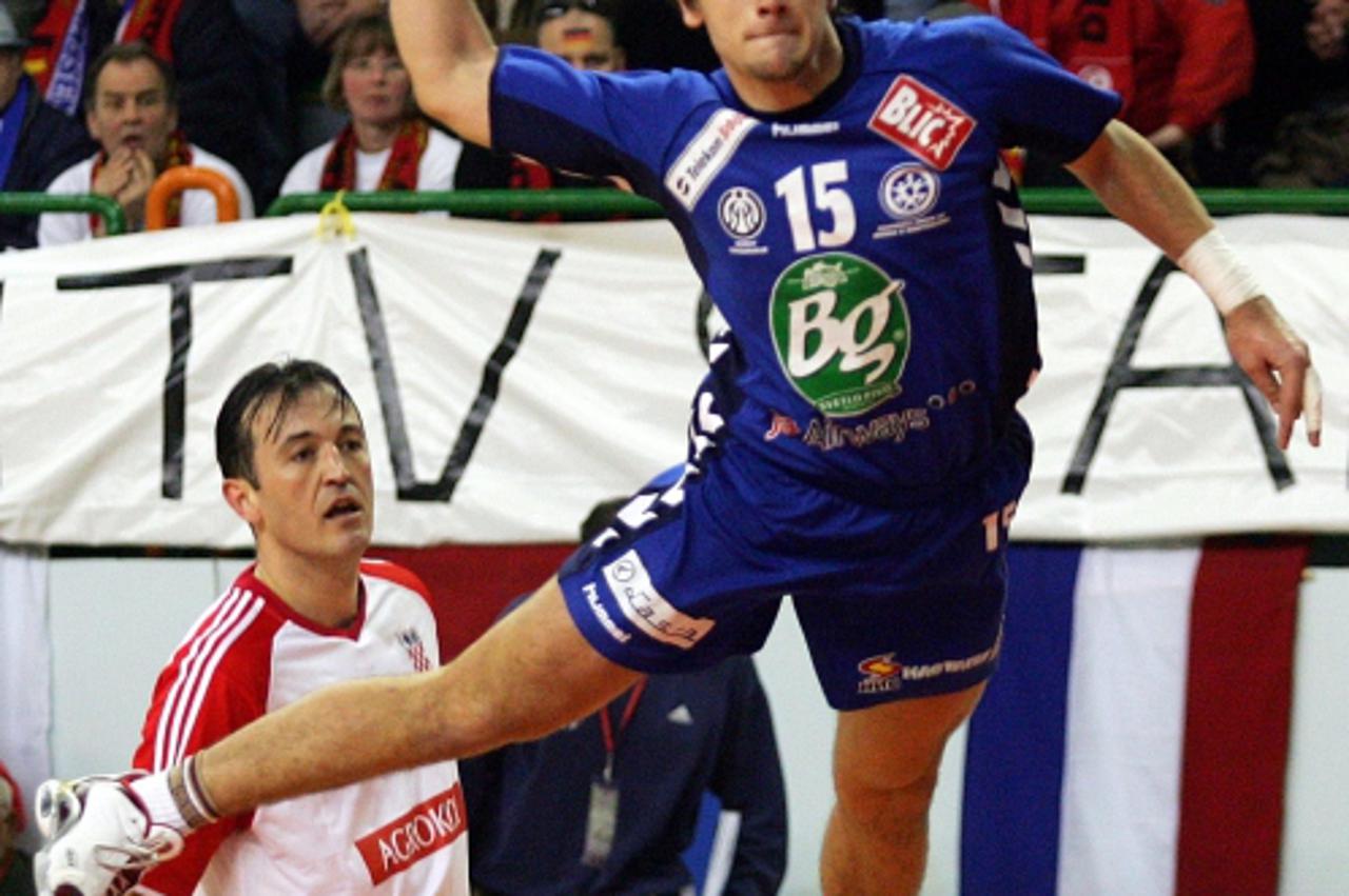 \'Serbia\'s Dragan Sudzum (R) leaps to score past Croatia\'s Slavko Goluza (L) during their Men\'s Handball World Championship second round match in Nabeul, Tunisia, February 3, 2005.   REUTERS/Jean P