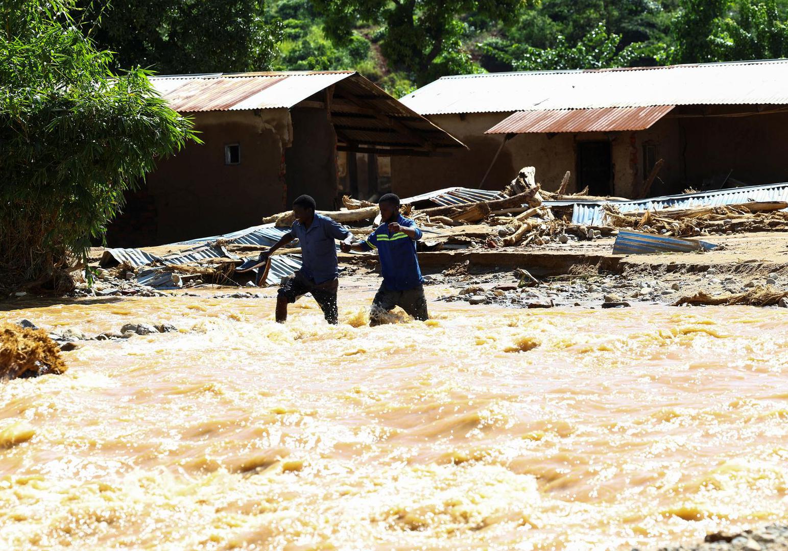 Locals cross a flooded area in Muloza on the border with Mozambique after the tropical Cyclone Freddy, around 100 km outside Blantyre, Malawi, March 18, 2023. REUTERS/Esa Alexander Photo: ESA ALEXANDER/REUTERS