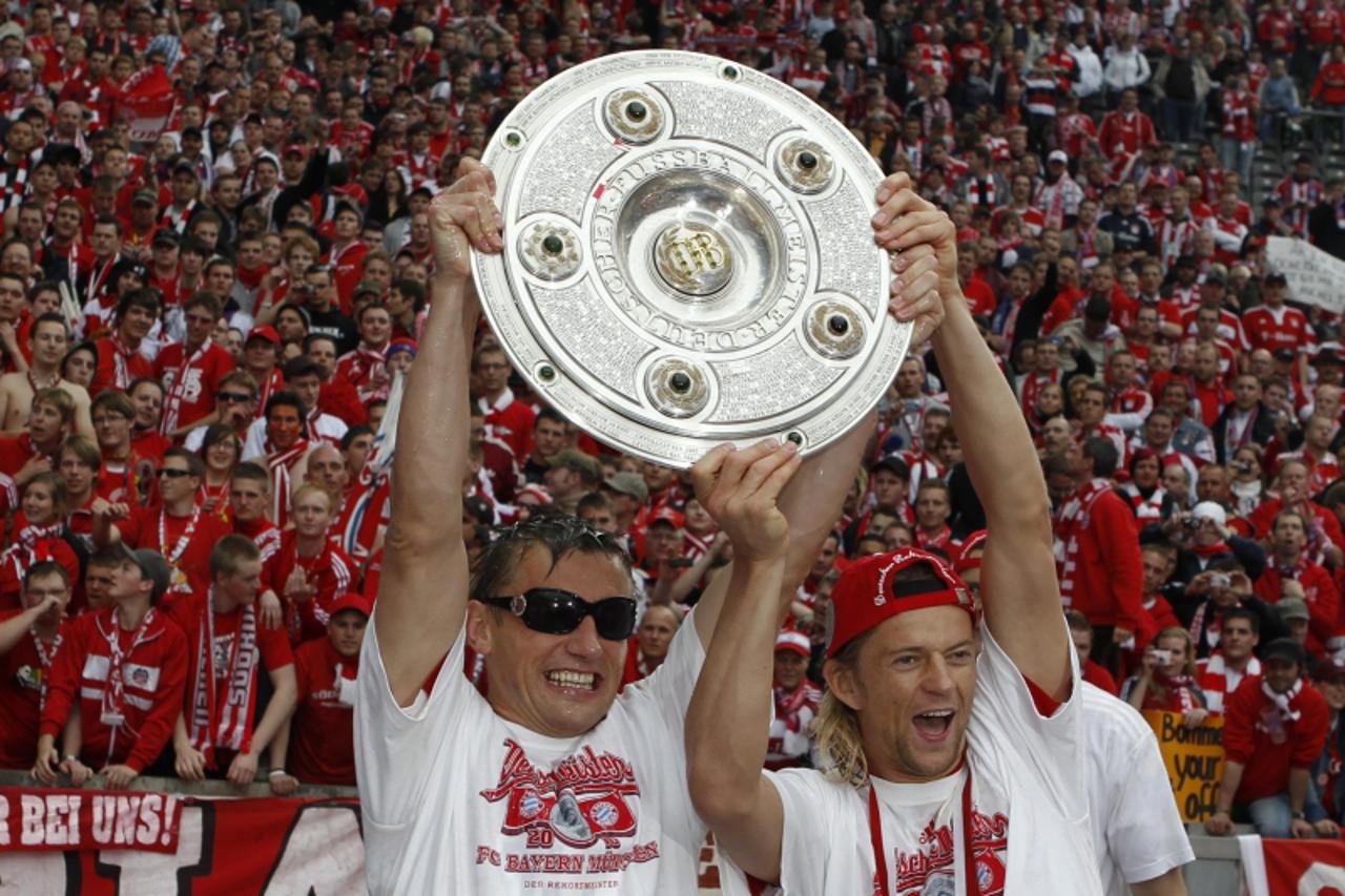 'Bayern Munich\'s Ivica Olic (L) and Anatoliy Tymoshchuk celebrate with the German soccer championship trophy after his team\'s first division Bundesliga soccer match against Hertha Berlin in Berlin M