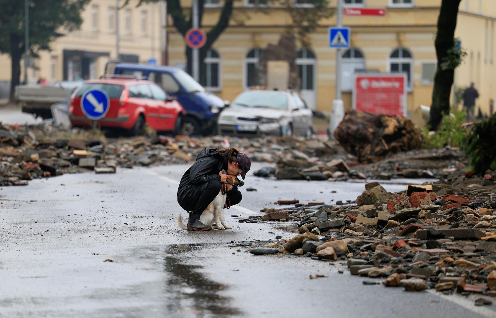 A woman kisses a dog as she sits on a road with debris, in the aftermath of flooding following heavy rainfalls, in Jesenik, Czech Republic, September 16, 2024. REUTERS/David W Cerny Photo: DAVID W CERNY/REUTERS