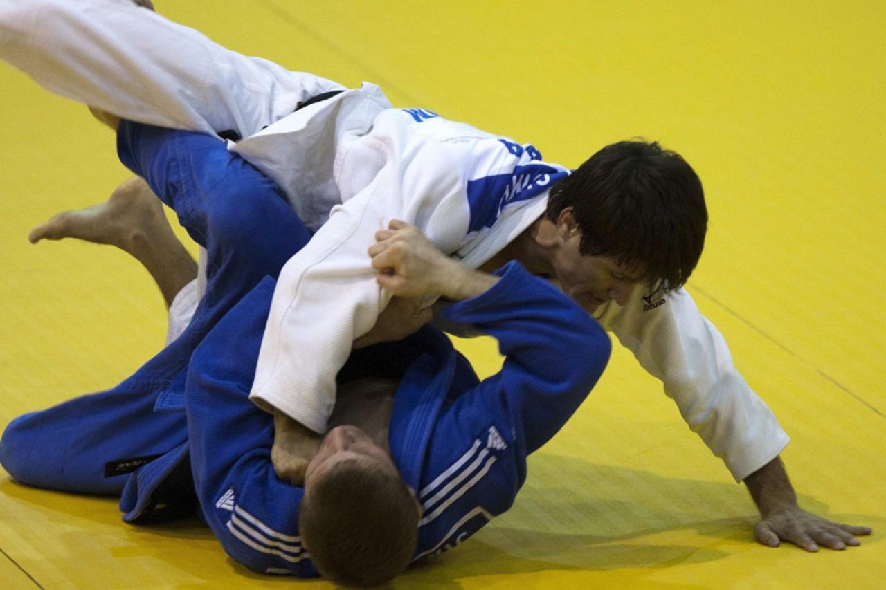 'Brazil\'s Leandro Cunha (in white) challenges Canada\'s Sacha Mehmedovic in their under 66kg final match at the Pan American Judo Championship in Montreal April 28, 2012.  REUTERS/Olivier Jean (CANAD