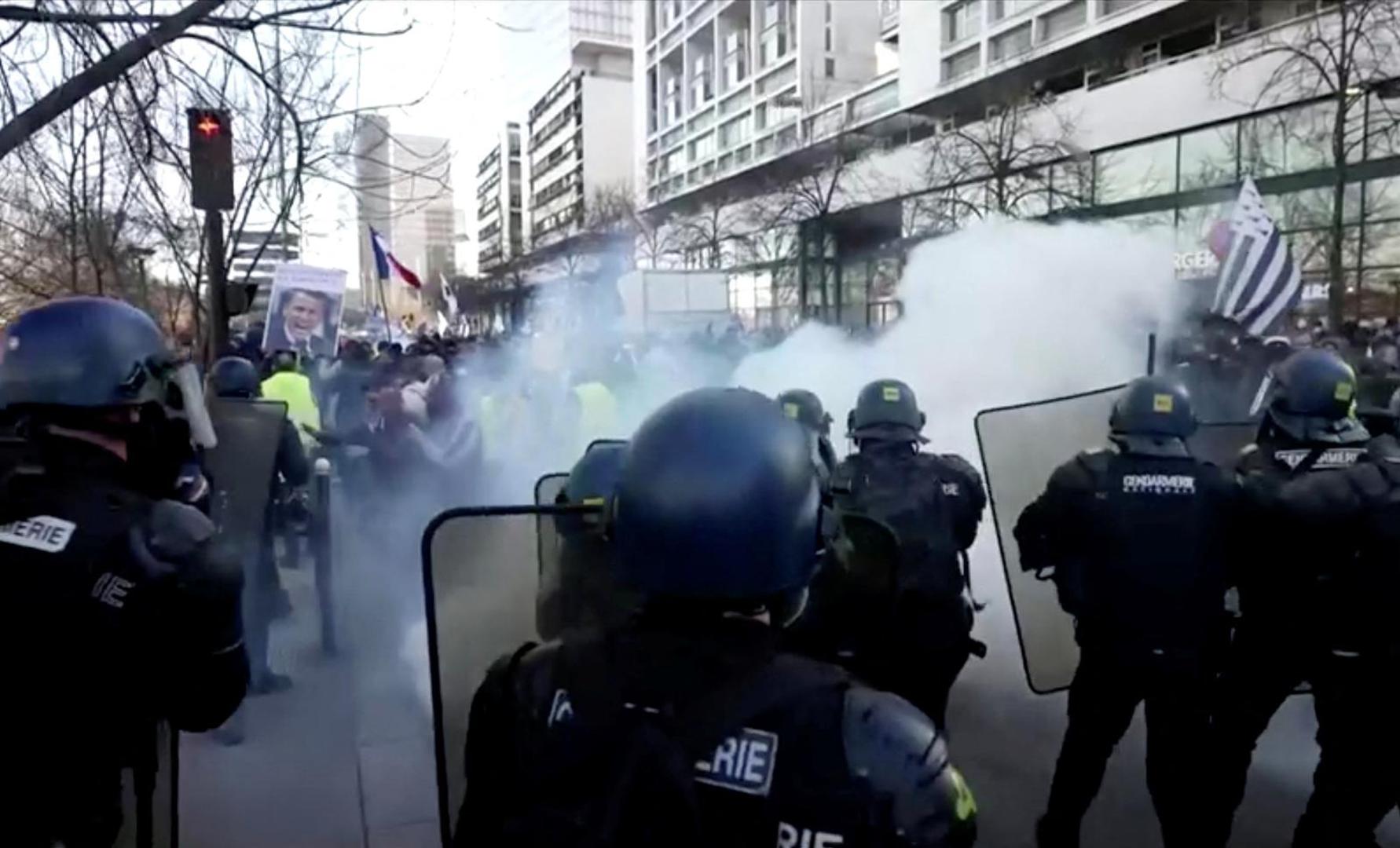 French police use teargas while facing demonstrators in this screen grab taken from a video during a "Convoi de la liberte" (The Freedom Convoy), a vehicular convoy to protest coronavirus disease (COVID-19) vaccine and restrictions in Paris, France, February 12, 2022. REUTERS via Reuters TV Photo: REUTERS TV/REUTERS