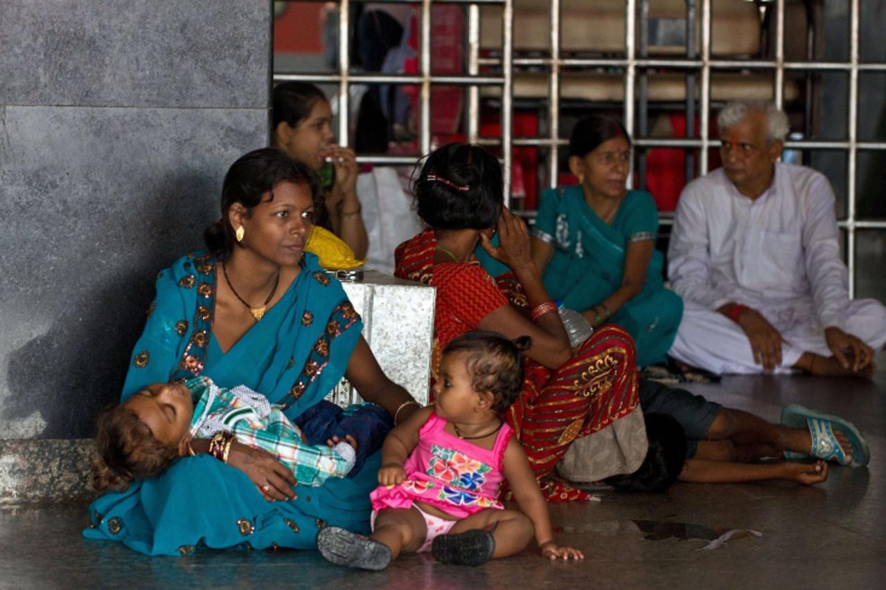 'Indian passengers wait for their train at a railway station following an overnight regionwide power outtage in New Delhi on July 30, 2012. A massive power cut blacked out a vast swathe of northern In