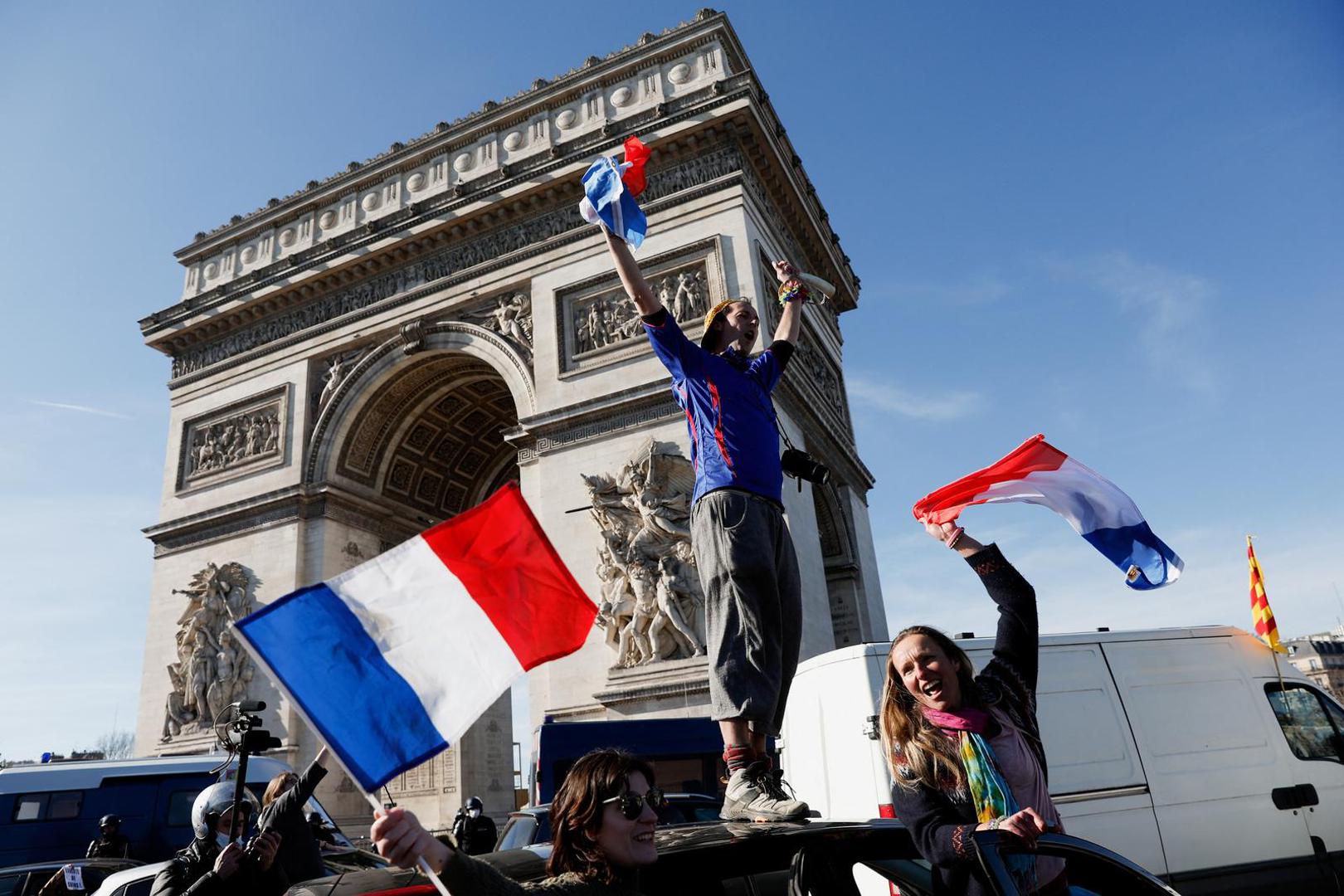 A protester stands atop a vehicle as cars parade during their "Convoi de la liberte" (The Freedom Convoy), a vehicular convoy to protest coronavirus disease (COVID-19) vaccine and restrictions in Paris, France, February 12, 2022. REUTERS/Benoit Tessier Photo: BENOIT TESSIER/REUTERS