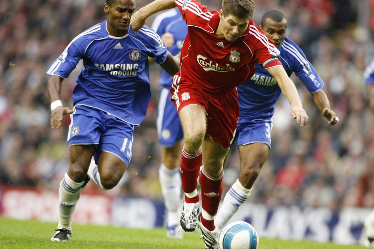 'Liverpool\'s Steven Gerrard (C) controls the ball in front of Chelsea\'s Florent Malouda (L) and Ashley Cole (R) during their English Premier League soccer match in Liverpool, northern England August