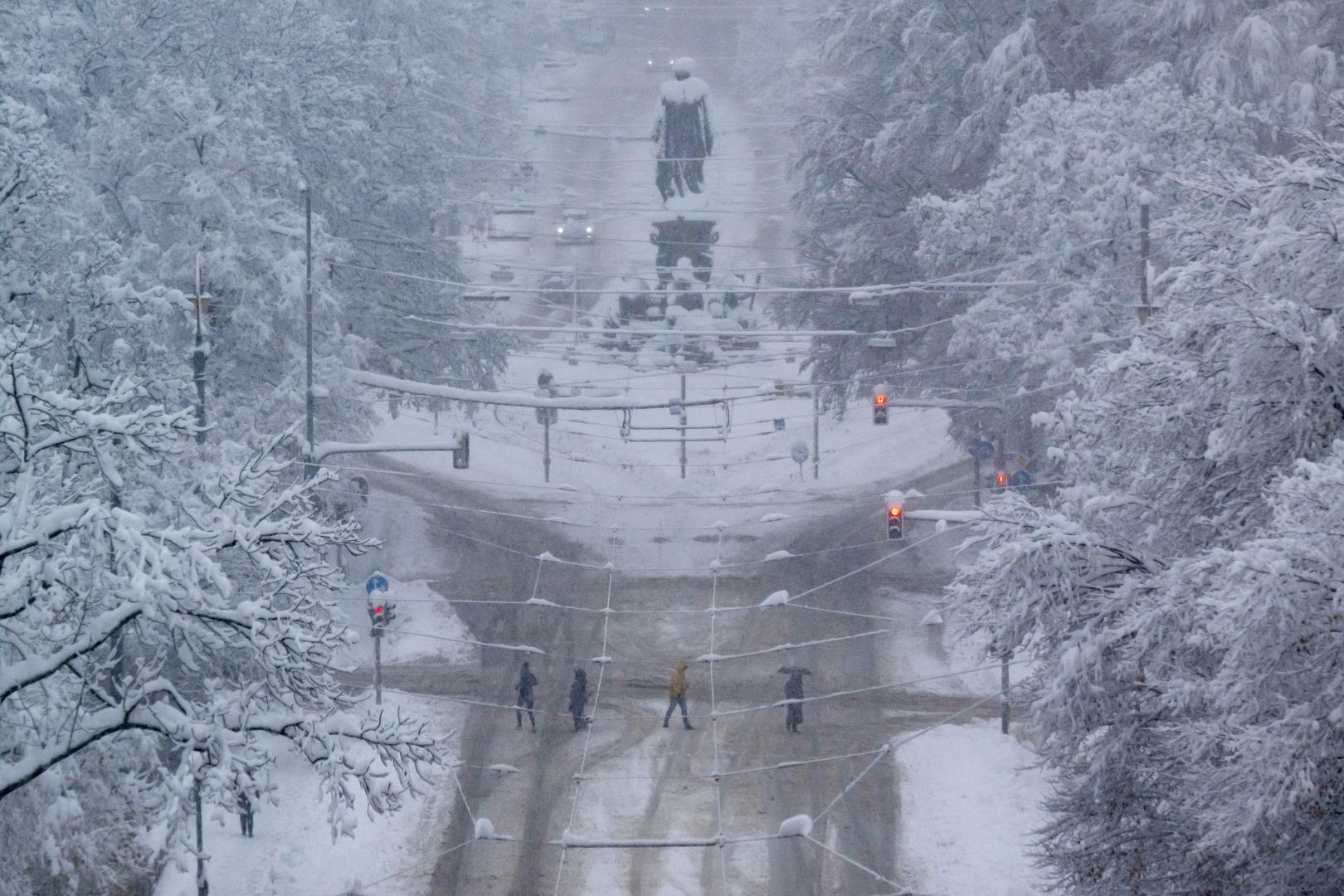 02 December 2023, Bavaria, Munich: Passers-by cross the Maximilianstraße around the Maxmonument, which has only been provisionally cleared. Snow and ice have caused chaos on the roads and on the railroads in the south of Bavaria. Photo: Peter Kneffel/dpa Photo: Peter Kneffel/DPA