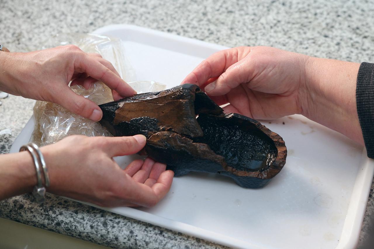 Archaeologist Silke Lange and a co-worker handle a 16th-century Dutch clog found in a cesspool in Alkmaar