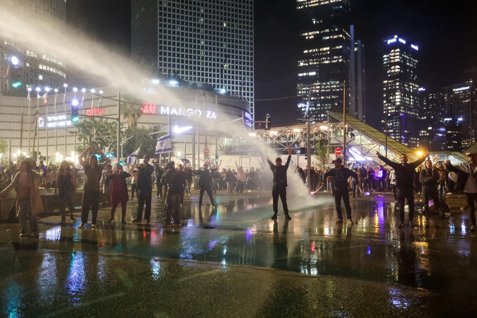 Israeli protesters stand with their arms up as a water cannon is used to disperse the people attending a demonstration against Israeli Prime Minister Benjamin Netanyahu and his nationalist coalition government's plan for judicial overhaul, in Tel Aviv, Israel, March 27, 2023. REUTERS/Itai Ron NO RESALES. NO ARCHIVES Photo: Stringer/REUTERS