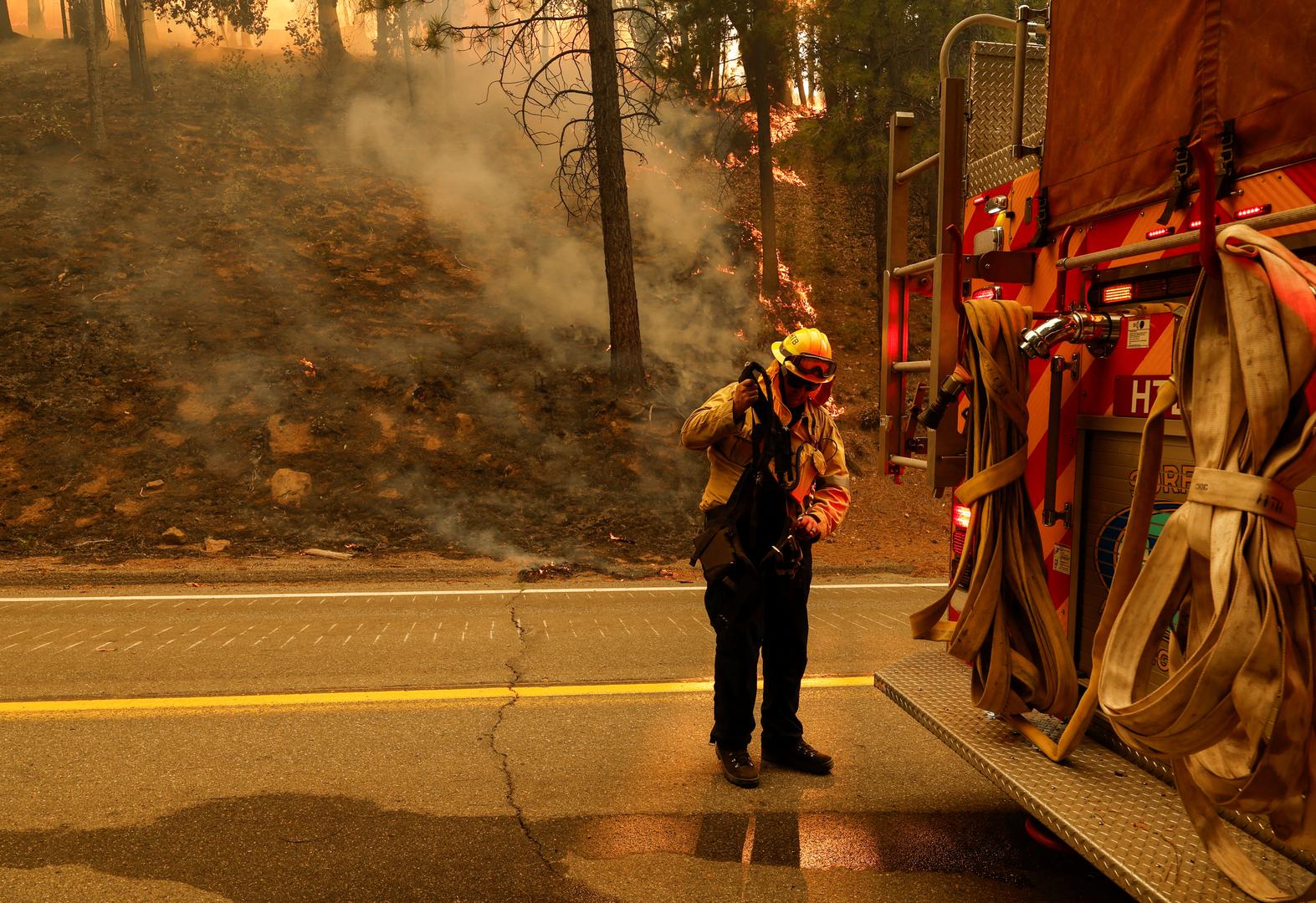 A firefighter puts on his brush gear at the back of a fire truck along Highway 32 near Forest Ranch, California, U.S. July 26, 2024. REUTERS/Fred Greaves Photo: FRED GREAVES/REUTERS