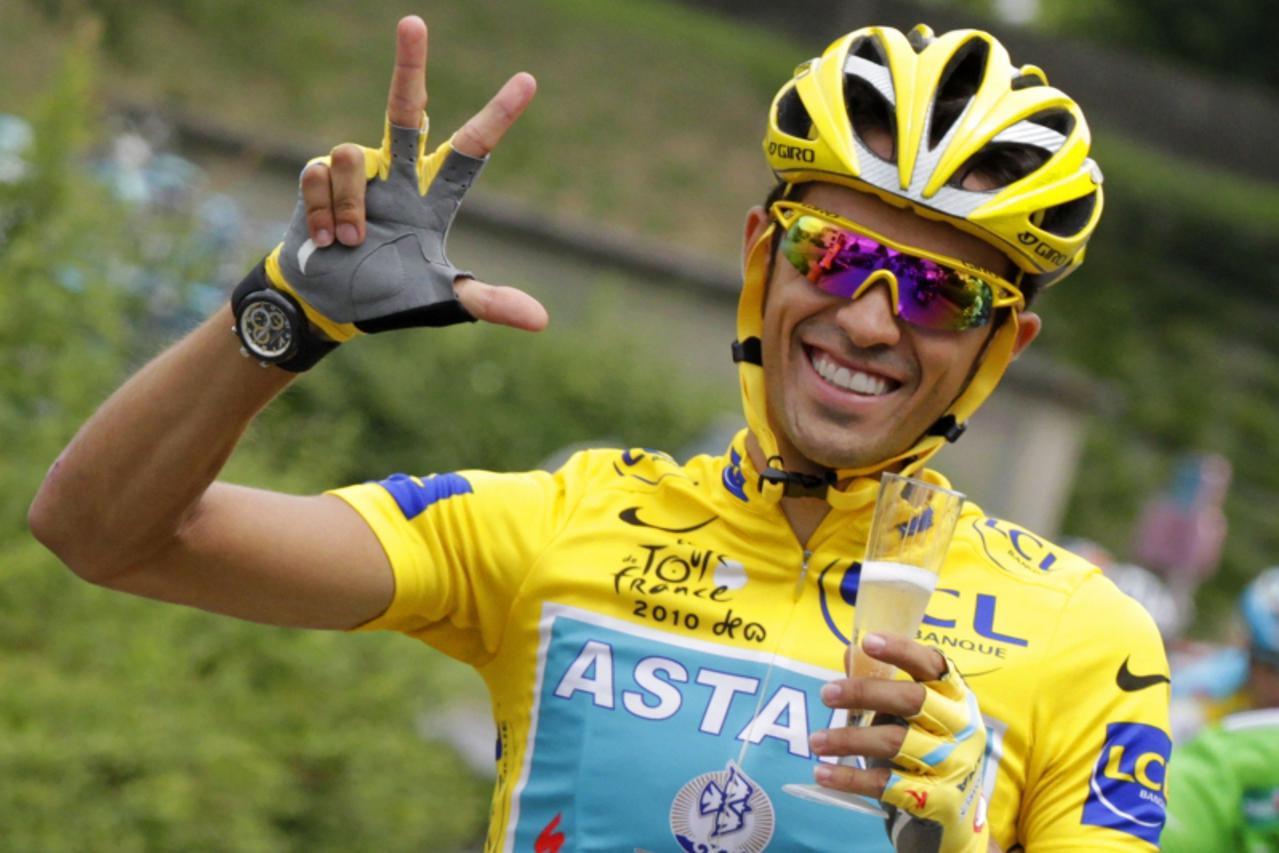 '(FILES) - A file picture taken on July 25, 2010 shows yellow jersey of overall leader, Spain\'s Alberto Contador making the sign three for three victories in the race as he drinks a glass of champagn