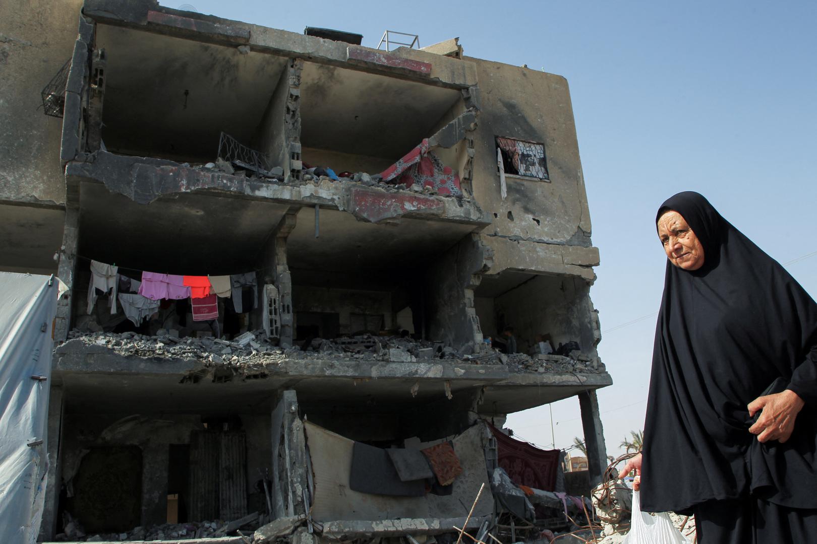 A Palestinian woman walks past a house destroyed by an Israeli strike, amid the ongoing conflict between Israel and the Palestinian Islamist group Hamas, in Rafah, southern Gaza Strip May 22, 2024. REUTERS/Hatem Khaled Photo: HATEM KHALED/REUTERS