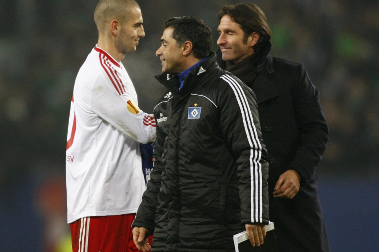 \'Hamburg SV\'s coach Bruno Labbadia (R), assistant coach Eddy Soezer and Mladen Petric (L) smile following their victory over Rapid Vienna in their Europa League soccer match in Hamburg December 2, 2