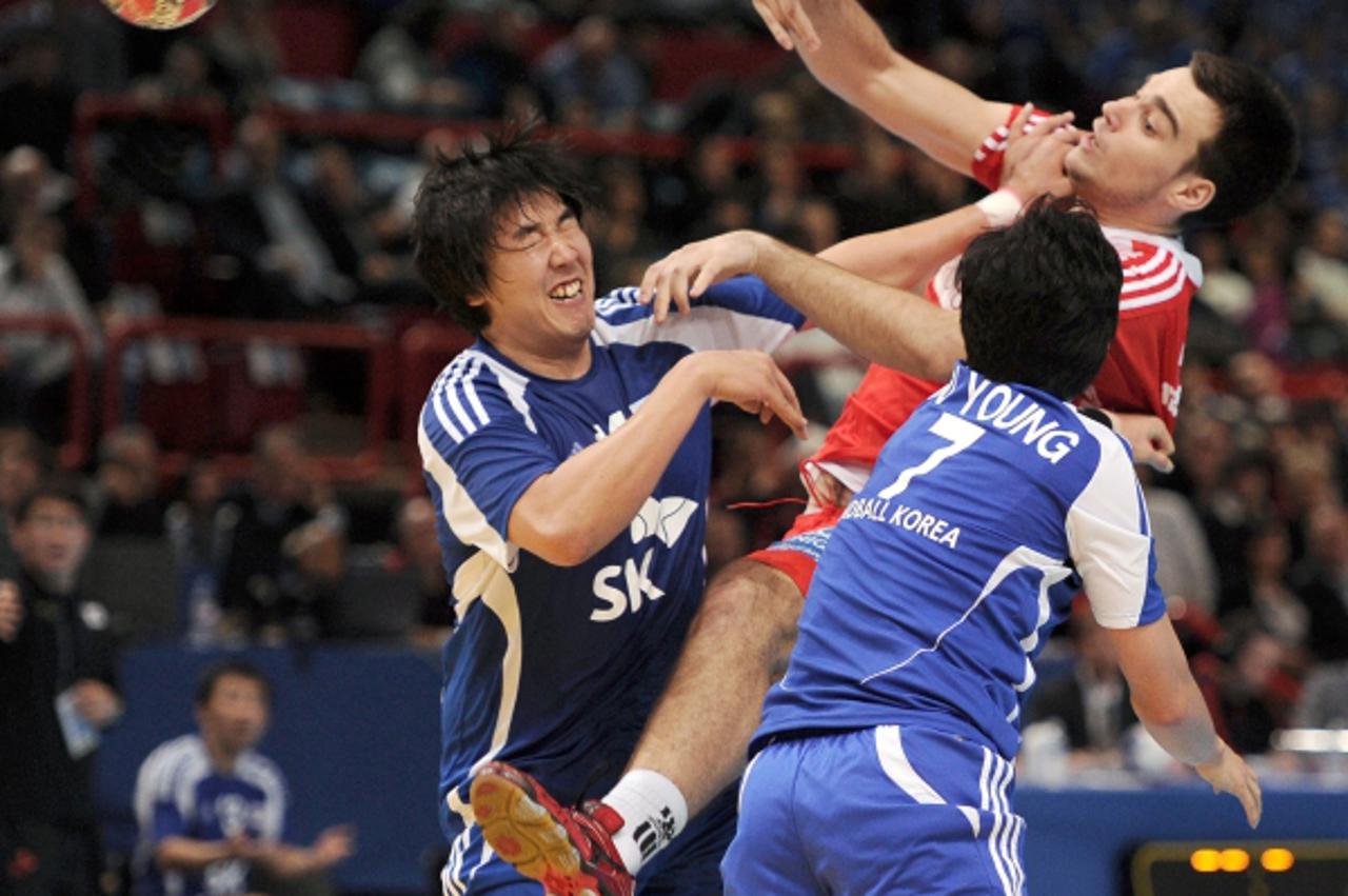 \'Croatia\'s Marino Malic (R) jumps to score a goal during the Paris handball tournament match Croatia vs. South Korea on January 8, 2011 at the Palais Omnisport de Paris-Bercy (POPB) in Paris. AFP PH