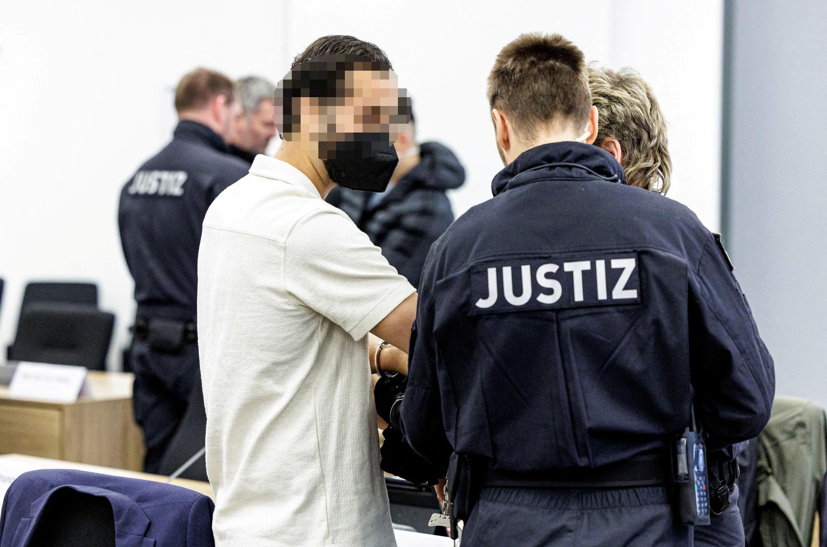 Defendant Mohamed R. is led in handcuffs by judicial officers into the courtroom of the Higher Regional Court prior to a hearing in the trial over a November 2019 jewellery heist on the Green Vault (Gruenes Gewoelbe) museum in Dresden's Royal Palace, in Dresden, Germany, March 20, 2023. Jens Schlueter/Pool via REUTERS IMAGE PIXELLATED AT SOURCE. GERMAN COURT REQUESTS THAT THE FACE OF THE DEFENDANT MUST BE MADE UNRECOGNISABLE REFILE - CORRECTING NAME Photo: POOL/REUTERS