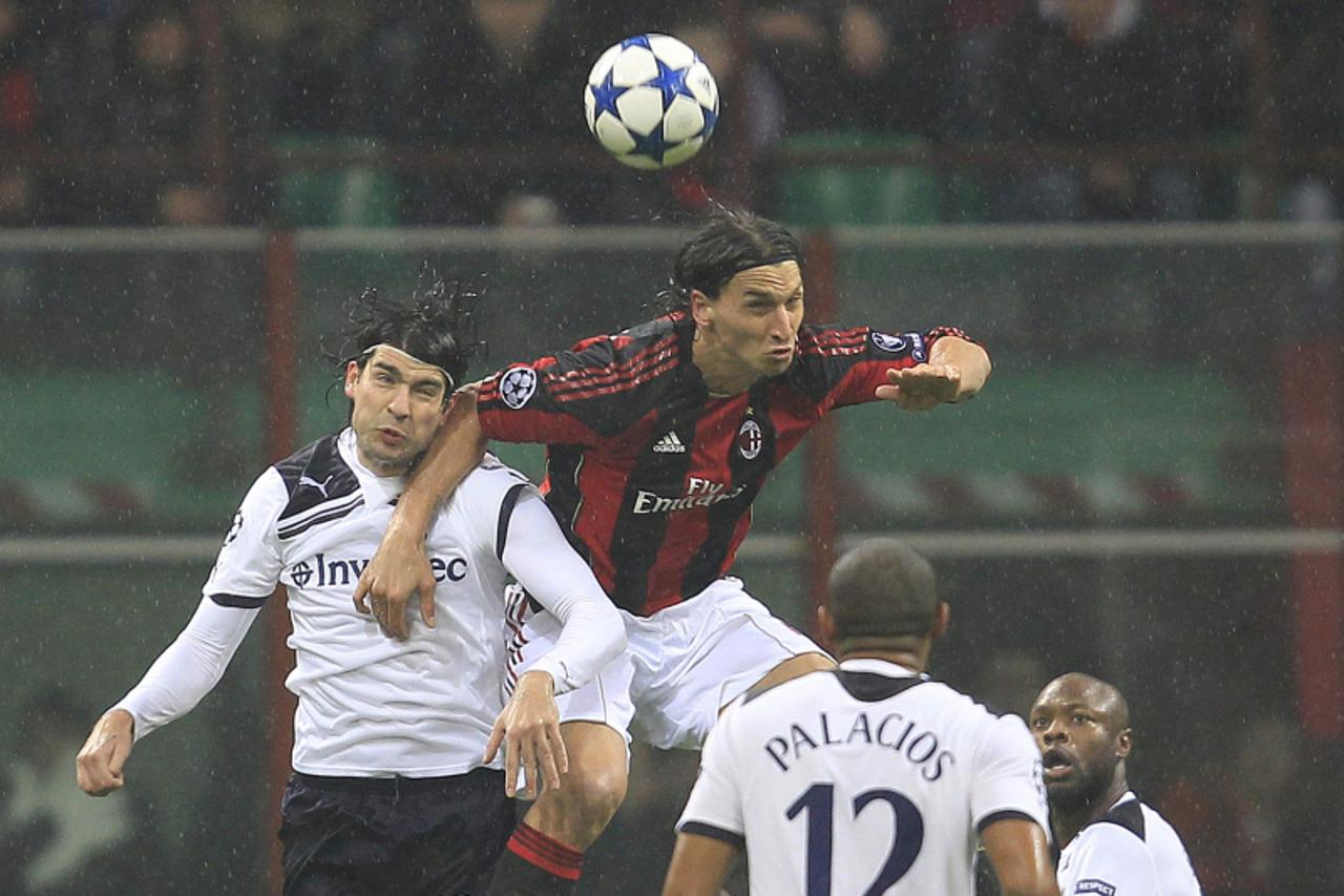 \'AC Milan\'s Zlatan Ibrahimovic (C) and Tottenham Hotspur\'s Vedran Corluka (L) jump for the ball during their Champions League soccer match at the San Siro stadium in Milan February 15, 2011. REUTER