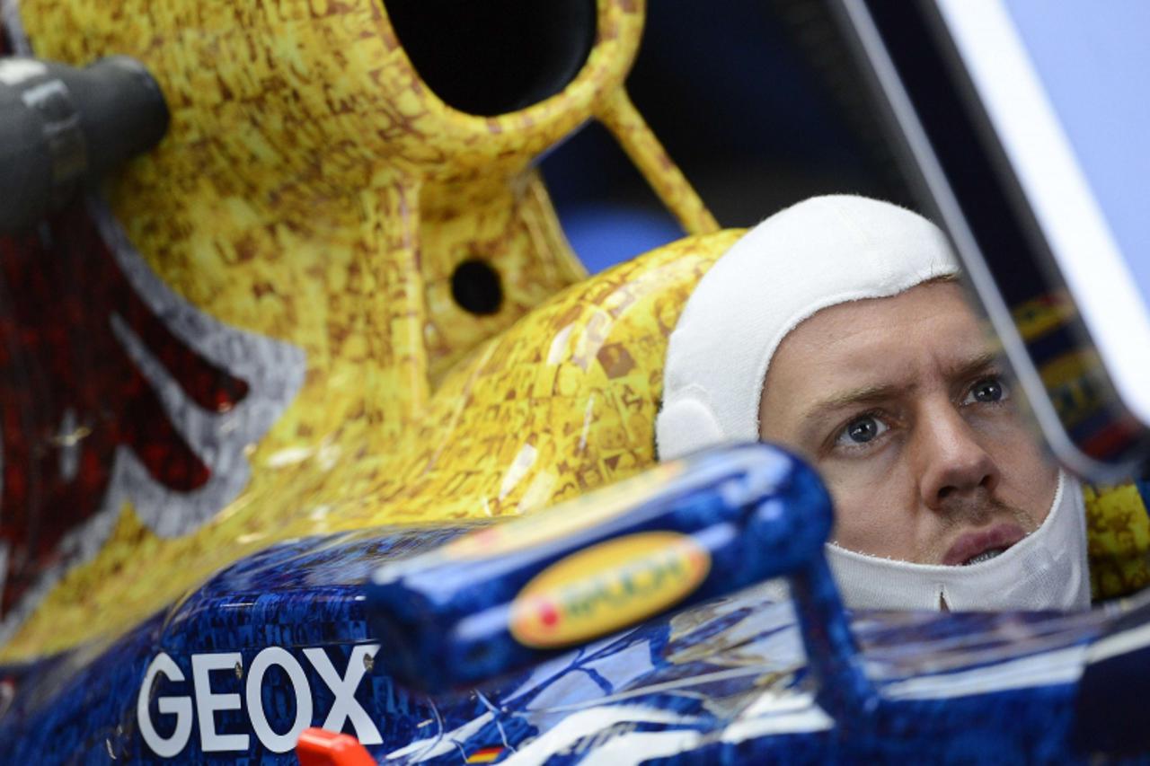 'Red Bull Formula One driver Sebastian Vettel of Germany sits in his car during the second practice of the British F1 Grand Prix at Silverstone circuit, central England, July 6, 2012. REUTERS/Nigel Ro