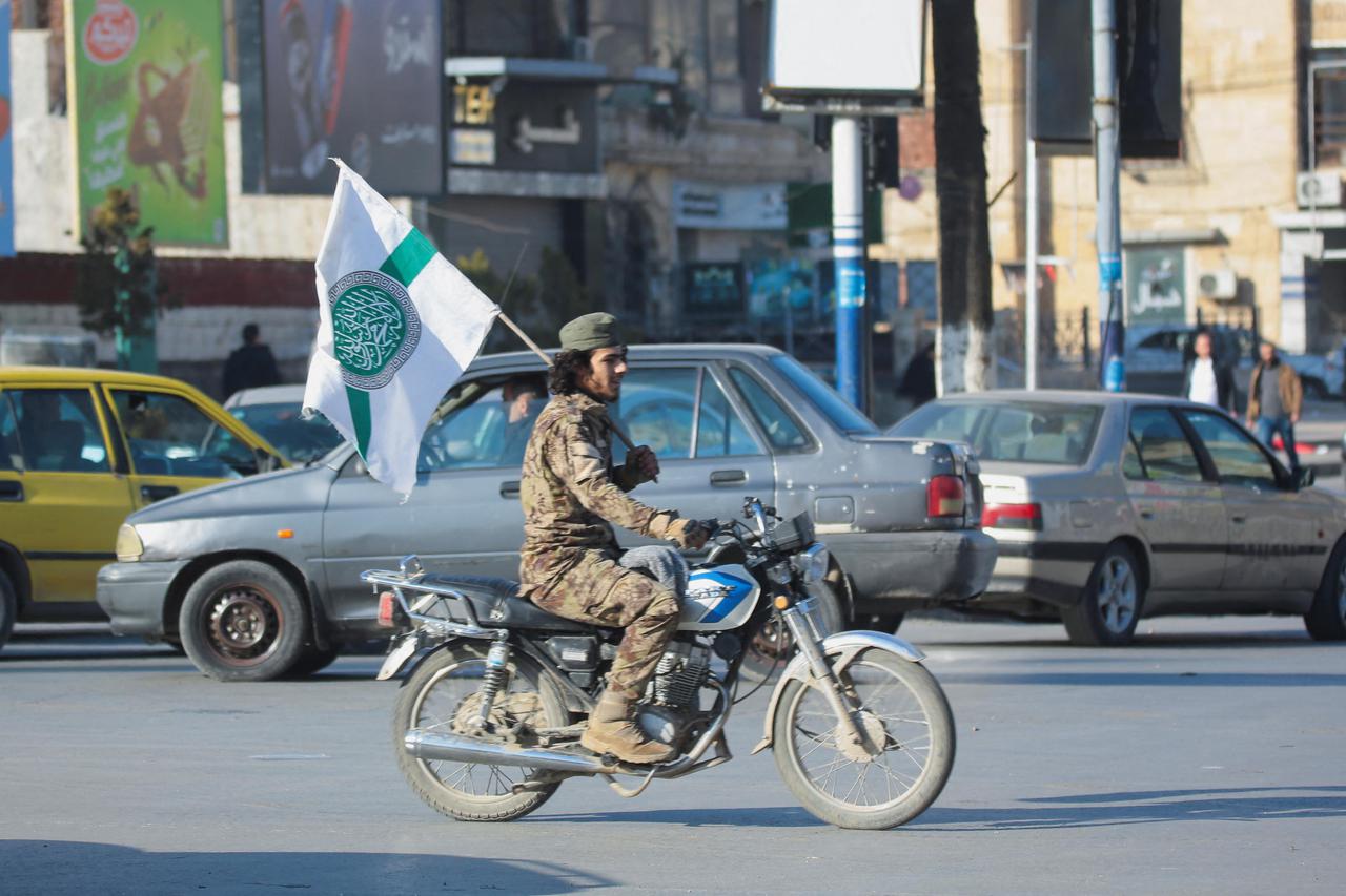 Syrian opposition fighter drives a motorbike in Aleppo, after the Syrian army said that dozens of its soldiers had been killed in a major attack by rebels who swept into the city